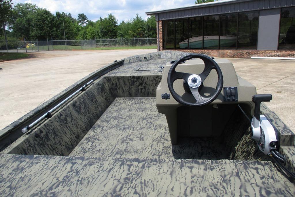 2026 Tracker GRIZZLY® 1648 SC boat with camouflage interior and steering console.