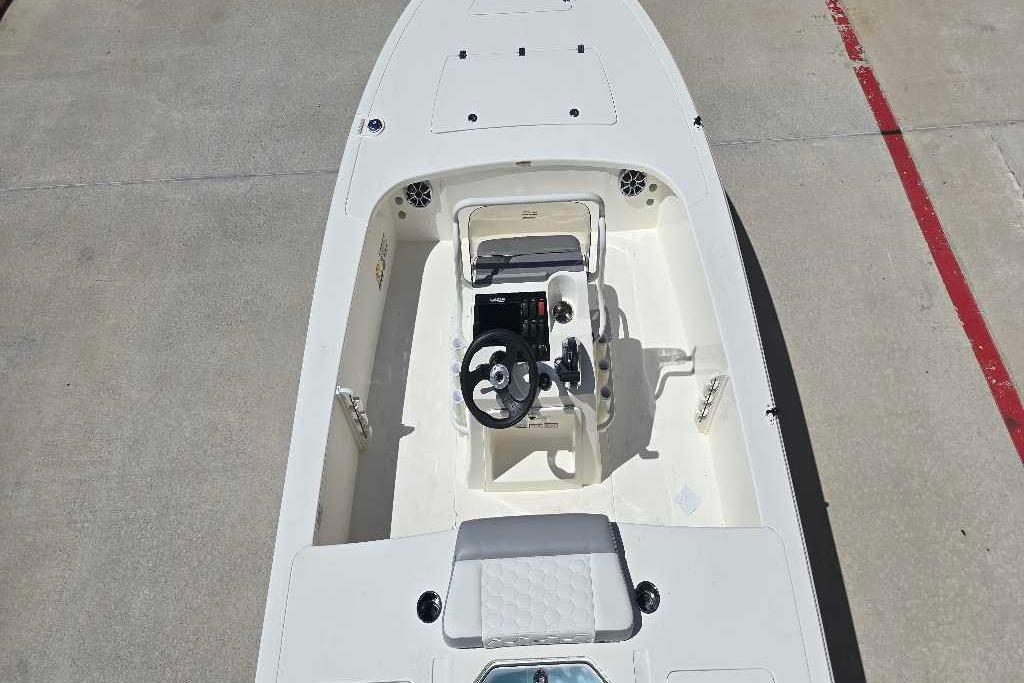2026 Mako 18 Pro Skiff boat interior with steering console, white deck, and seating.