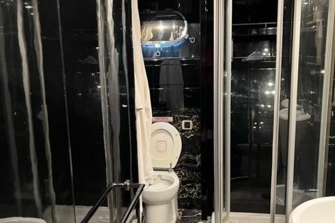 Luxurious bathroom in 2001 Maiora 24 yacht with sleek black and chrome finishes.