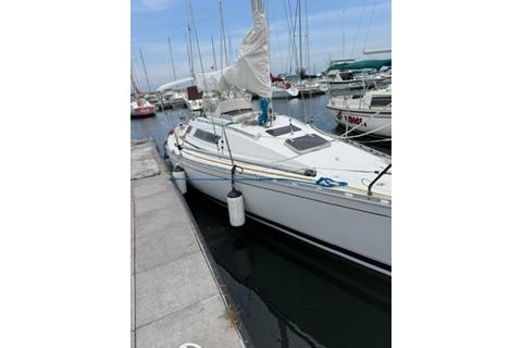 1986 Beneteau First 305 sailboat docked at marina, white hull, calm waters.