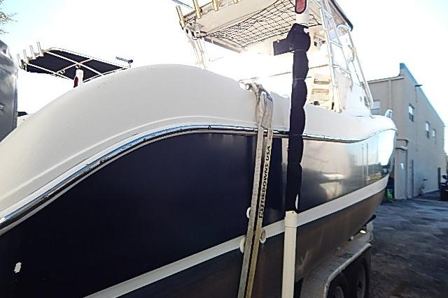 2003 World Cat 270 EC boat on trailer, side view in outdoor setting.
