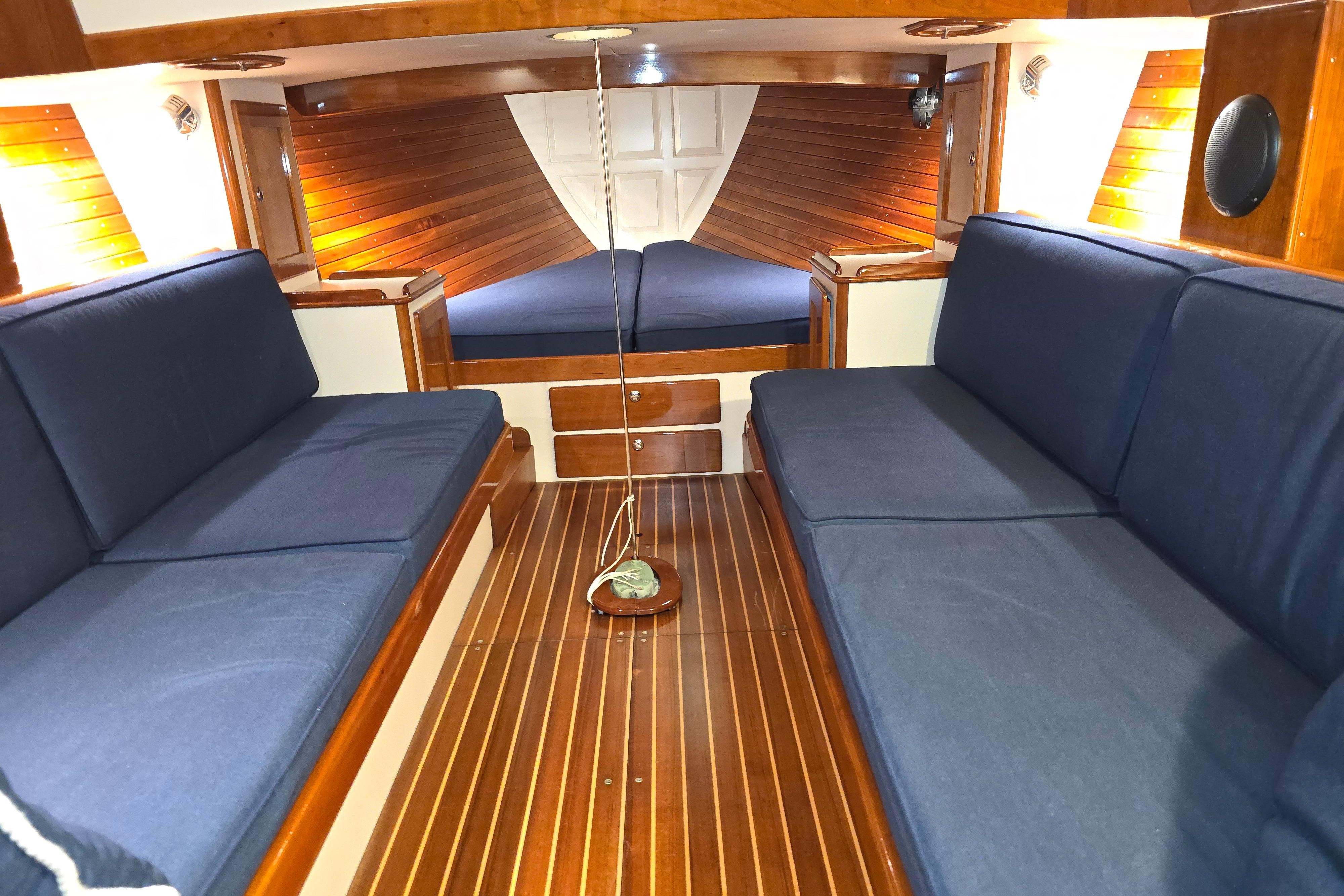 Interior of 2016 Morris M36 yacht with wooden finish and blue seating.