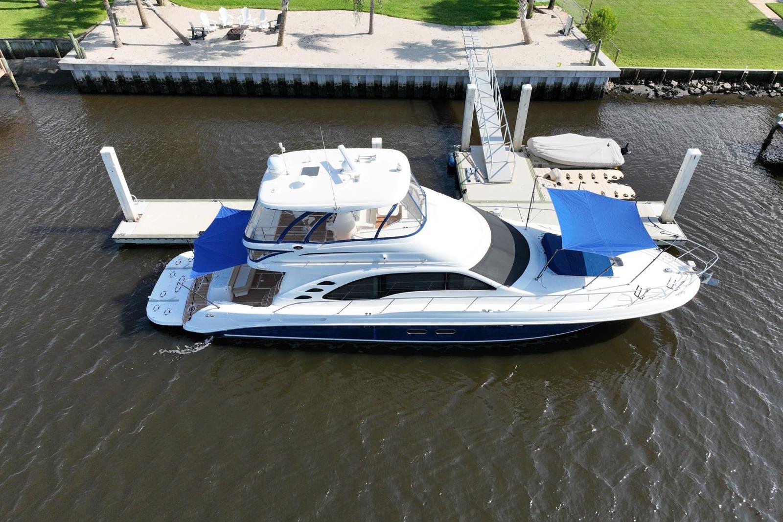2006 Sea Ray 580 Sedan Bridge yacht docked at marina with blue canopies.