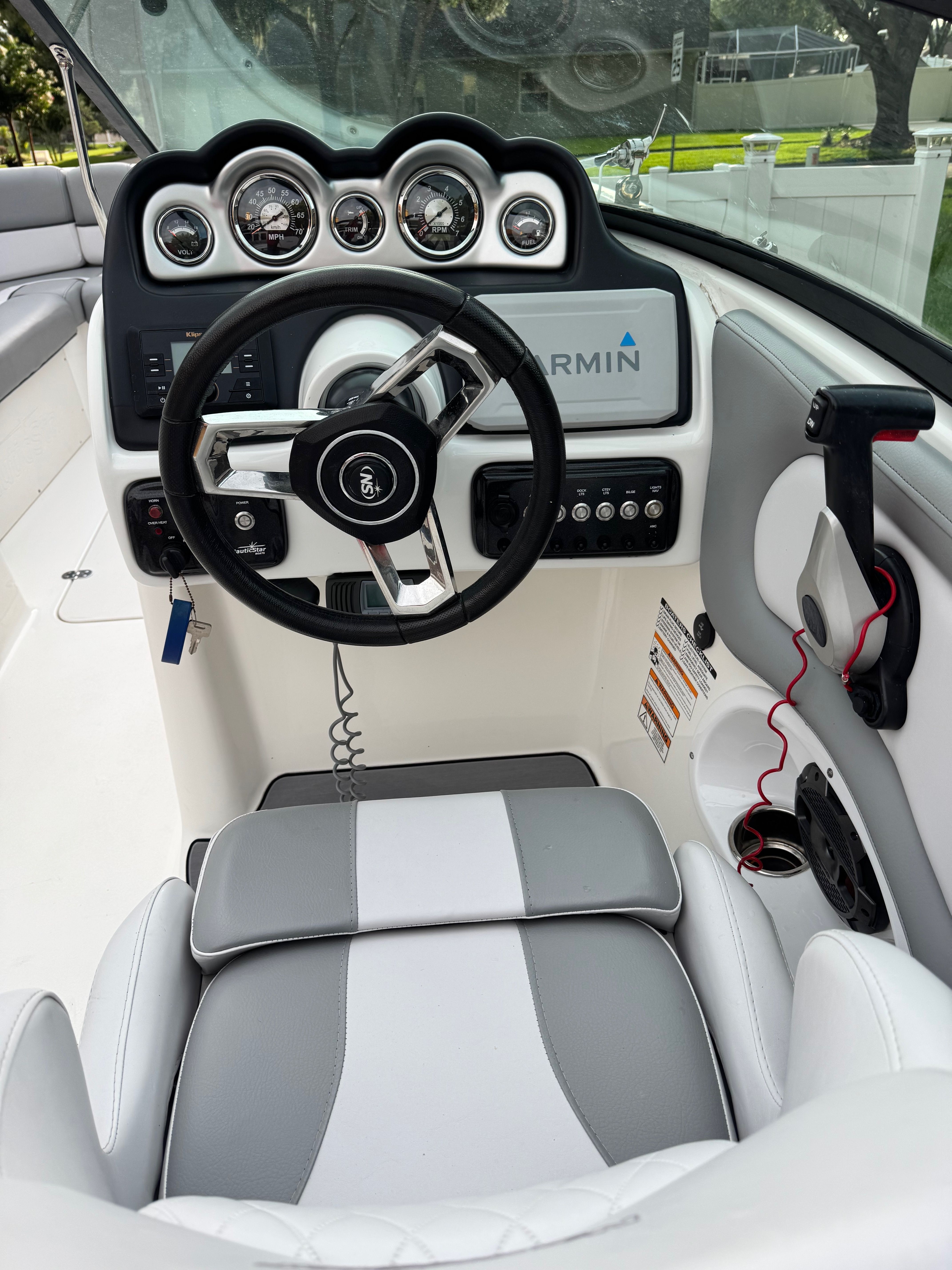 The image shows the helm of a 2022 NauticStar 243 DC boat with modern instruments.