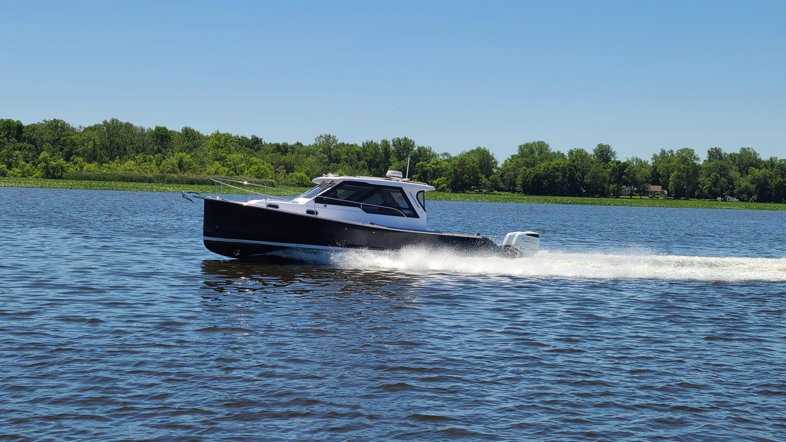 2024 True North 34 boat cruising on a lake under clear blue skies.