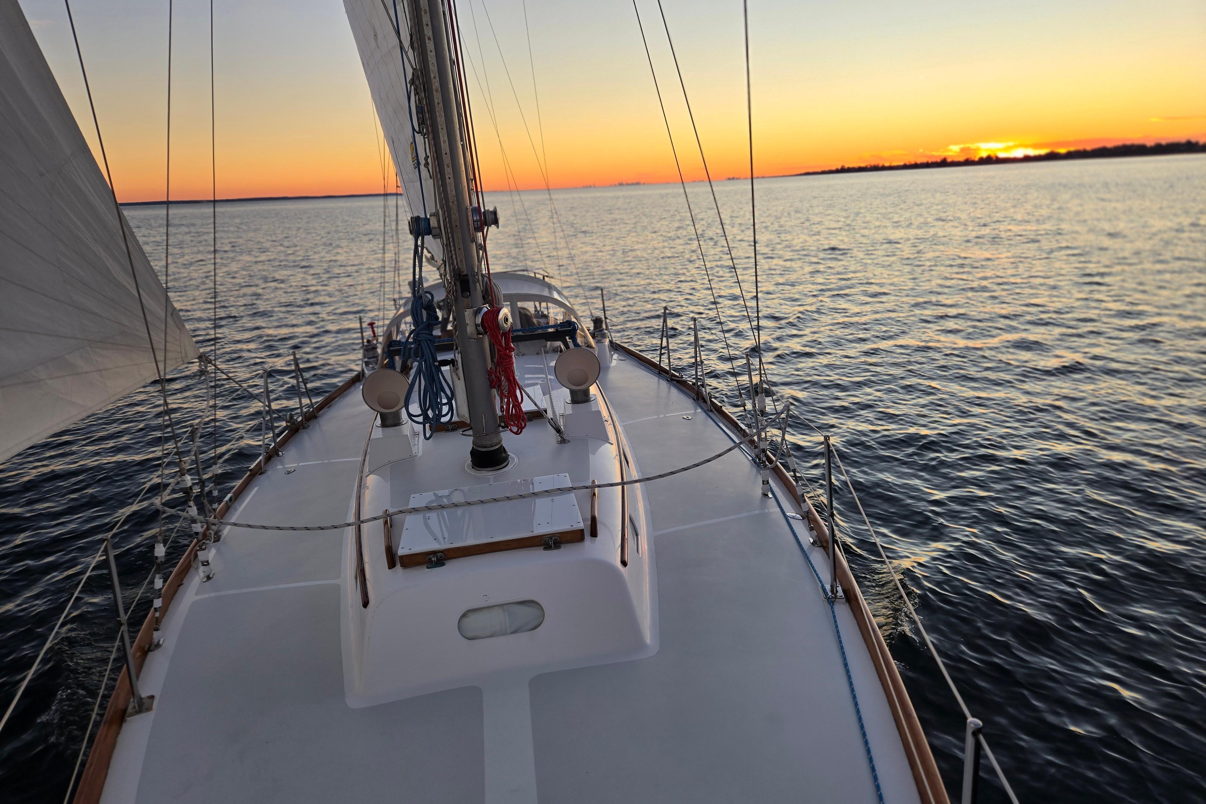 Hinckley Bermuda 40 sailboat on calm waters at sunset, 1970 model.