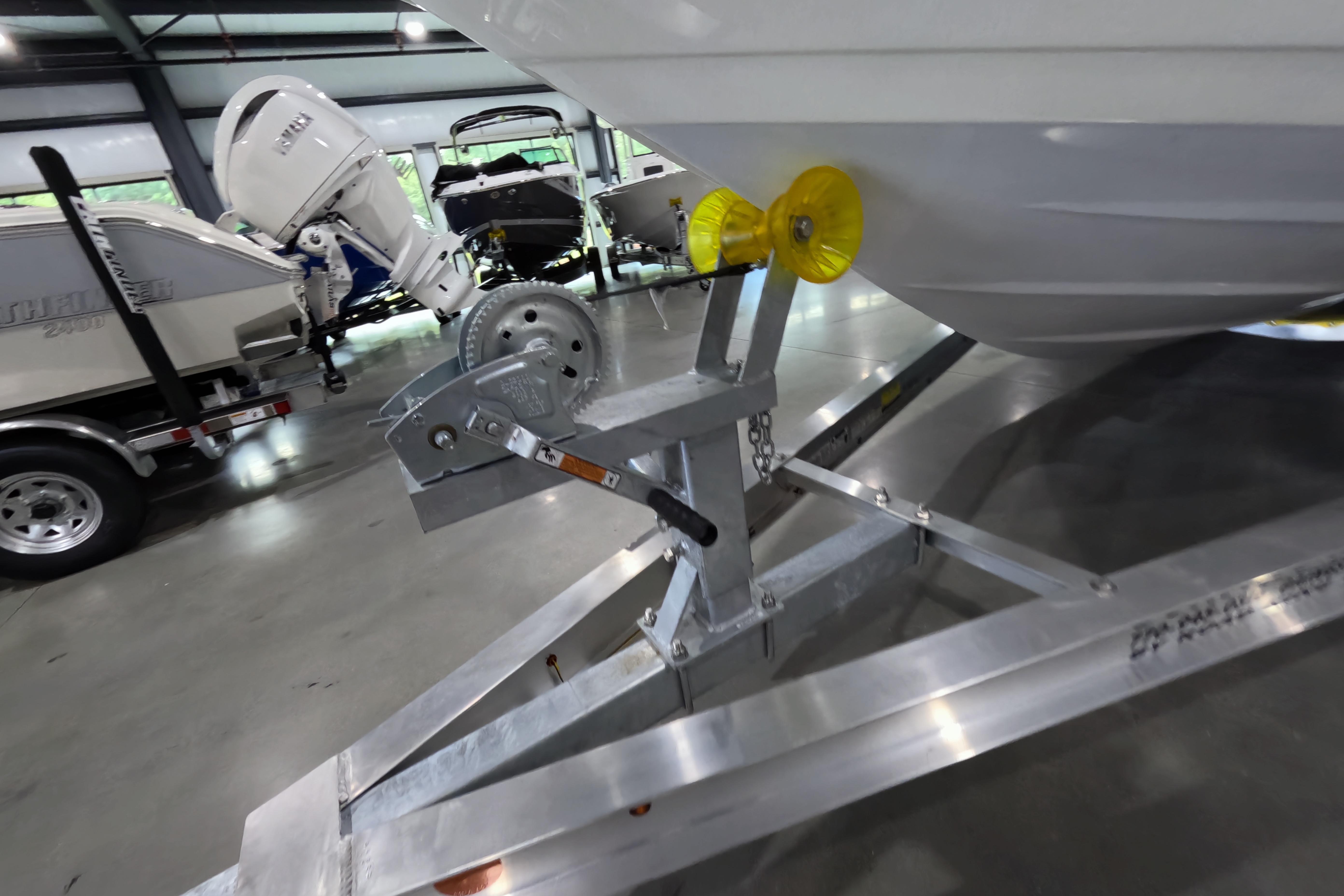 2026 Skeeter SX230 boat on trailer in showroom, featuring outboard motor.