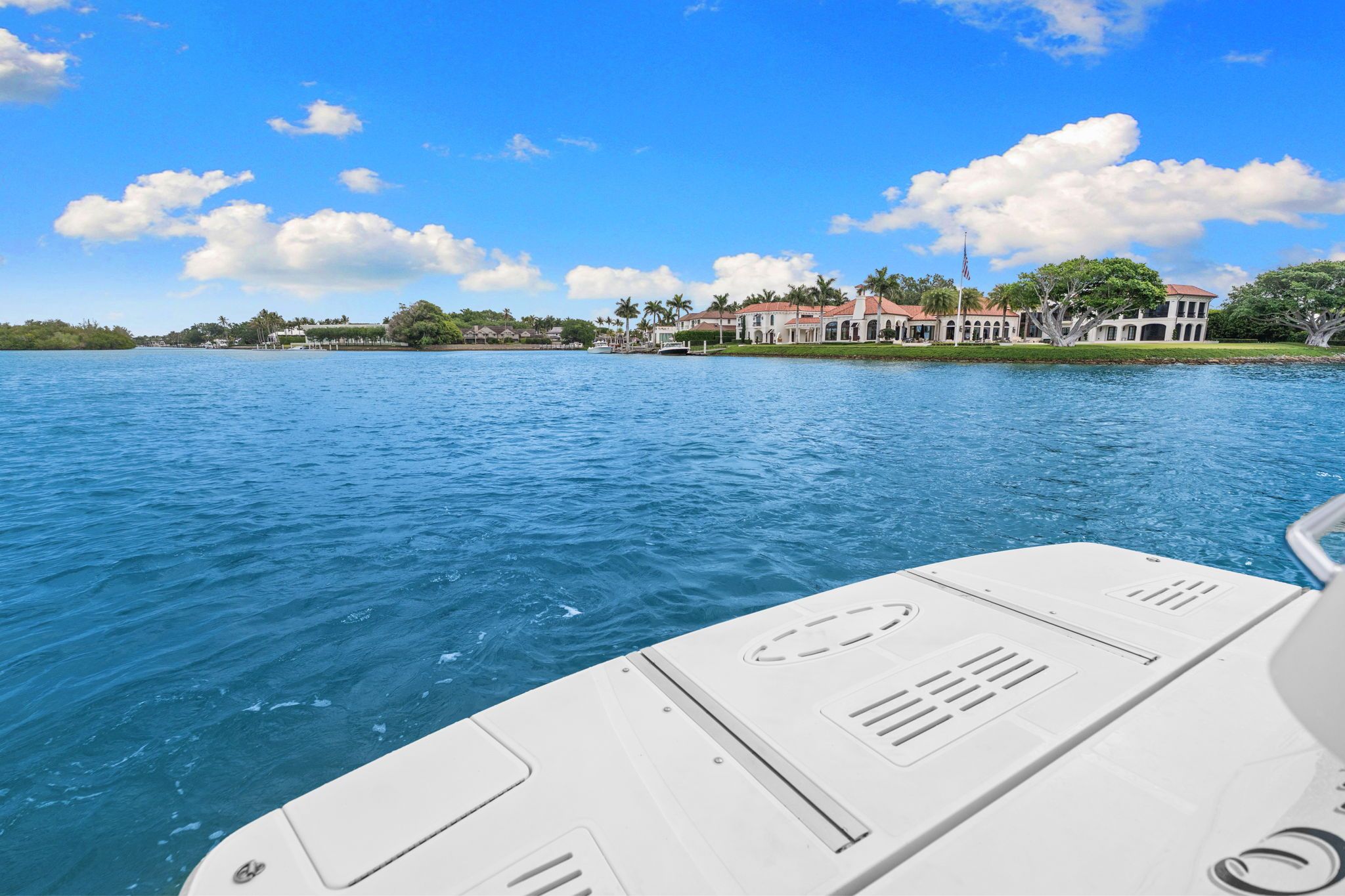 View from a boat of blue water and a shoreline with houses.