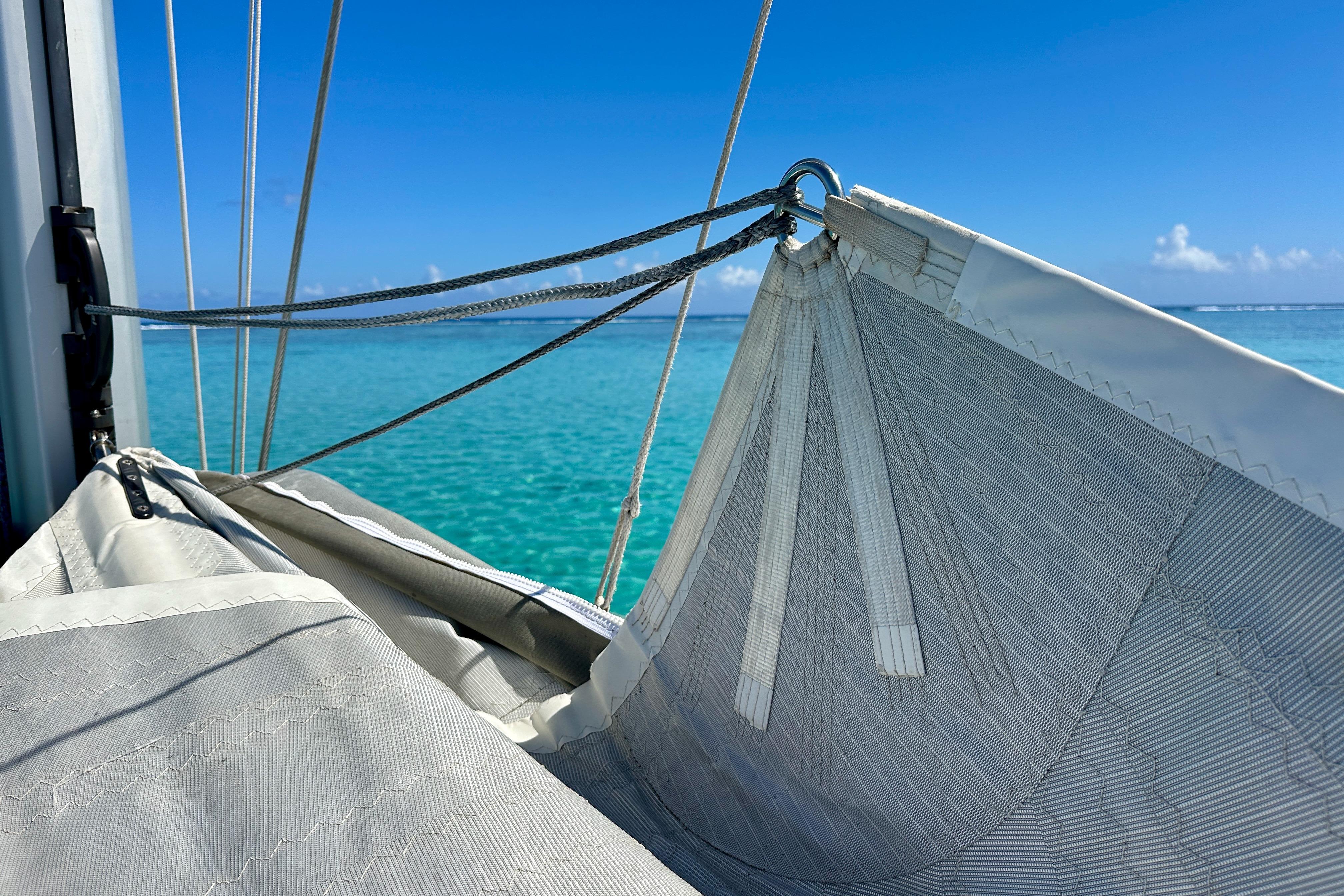 Sail detail on 2019 Outremer 45 catamaran against turquoise sea and clear blue sky.
