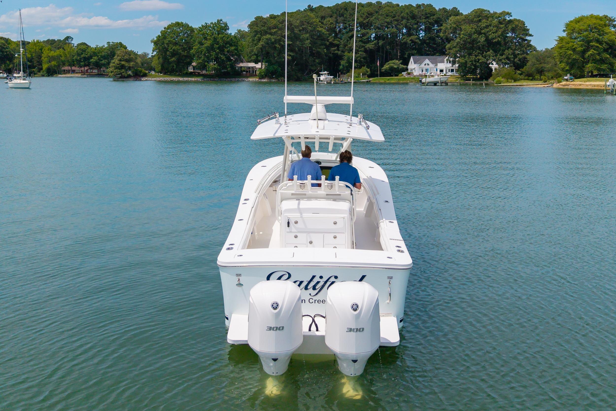 2019 Regulator 31 boat cruising on a serene lake with two passengers.