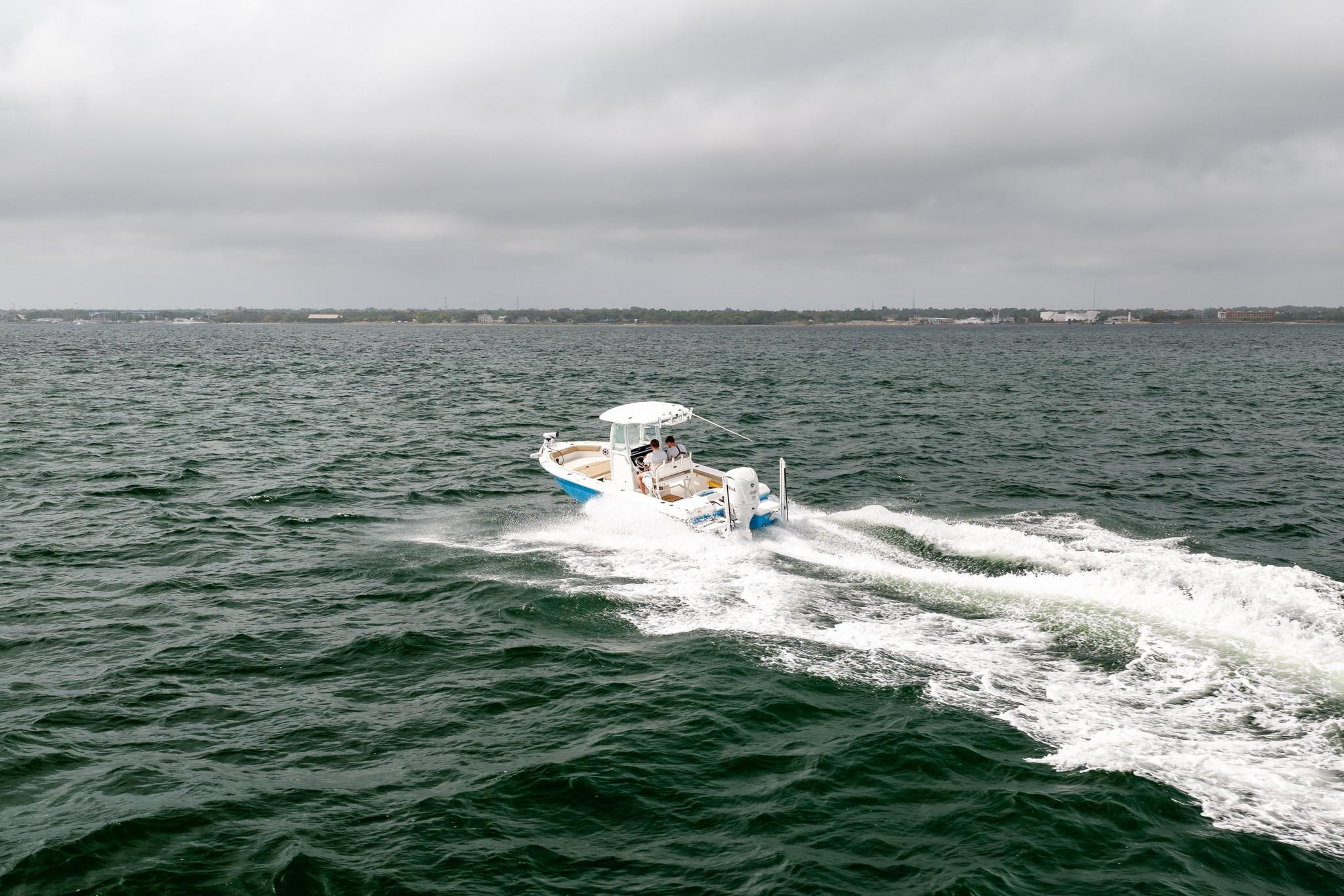 2023 Everglades 243 Center Console boat cruising on open water under cloudy skies.