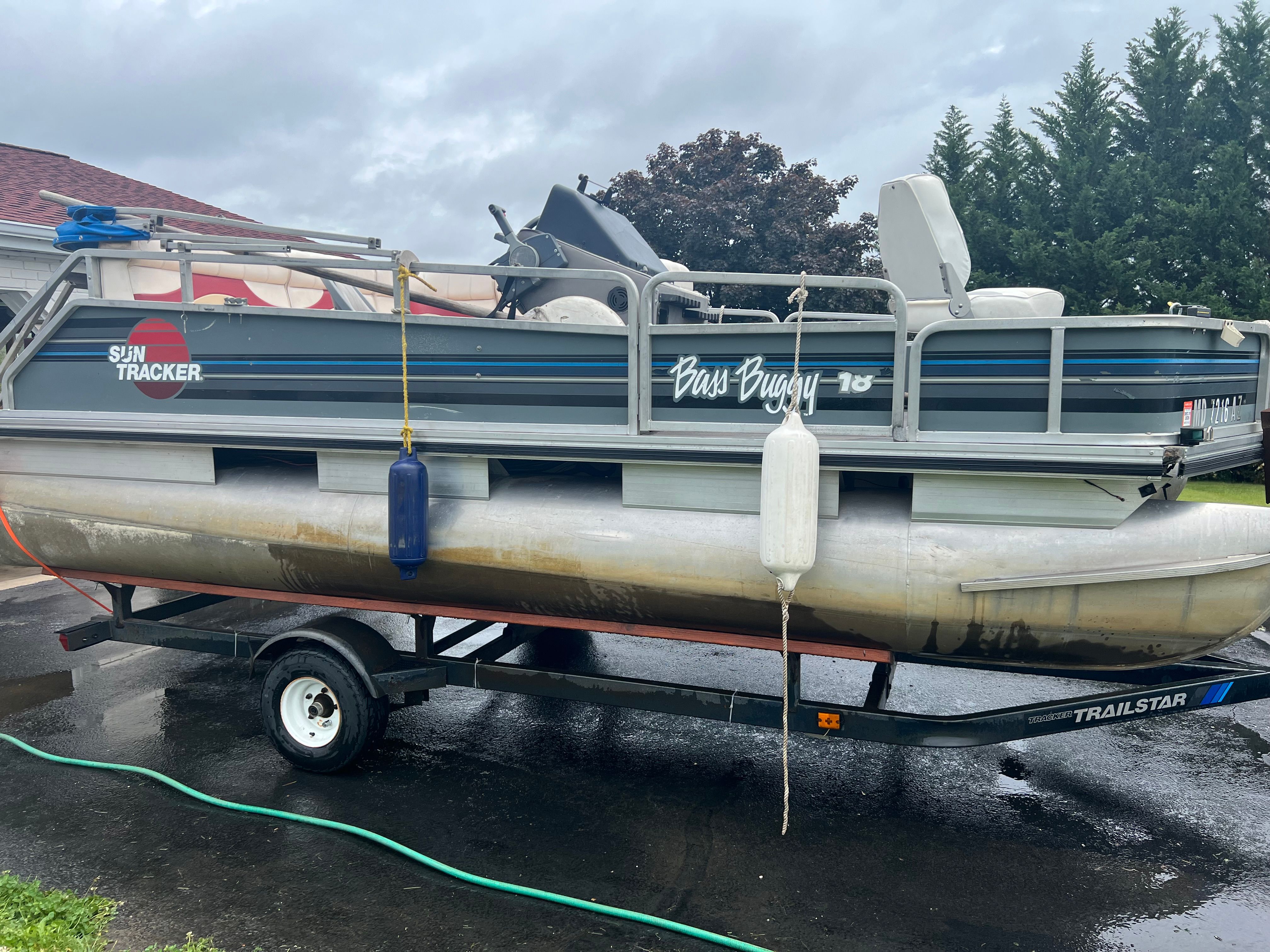 1991 Tracker Bass Buggy pontoon boat on trailer, side view.