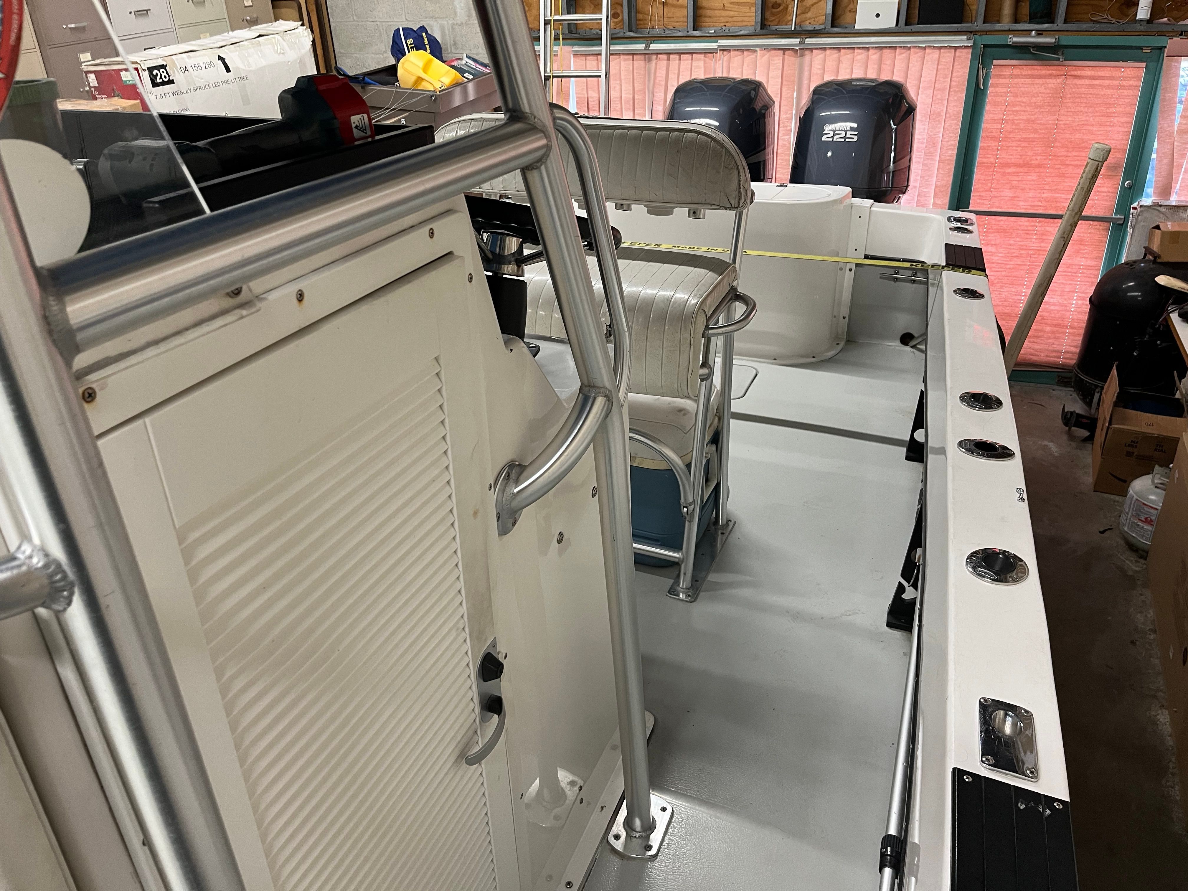 The image shows the interior of a 2002 Dusky 25.6 boat with seating and a helm console.