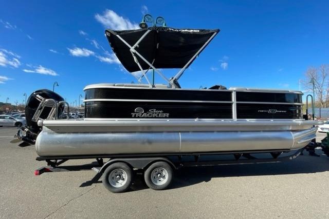 2026 Sun Tracker Party Barge 22 DLX pontoon boat on trailer, under clear blue sky.