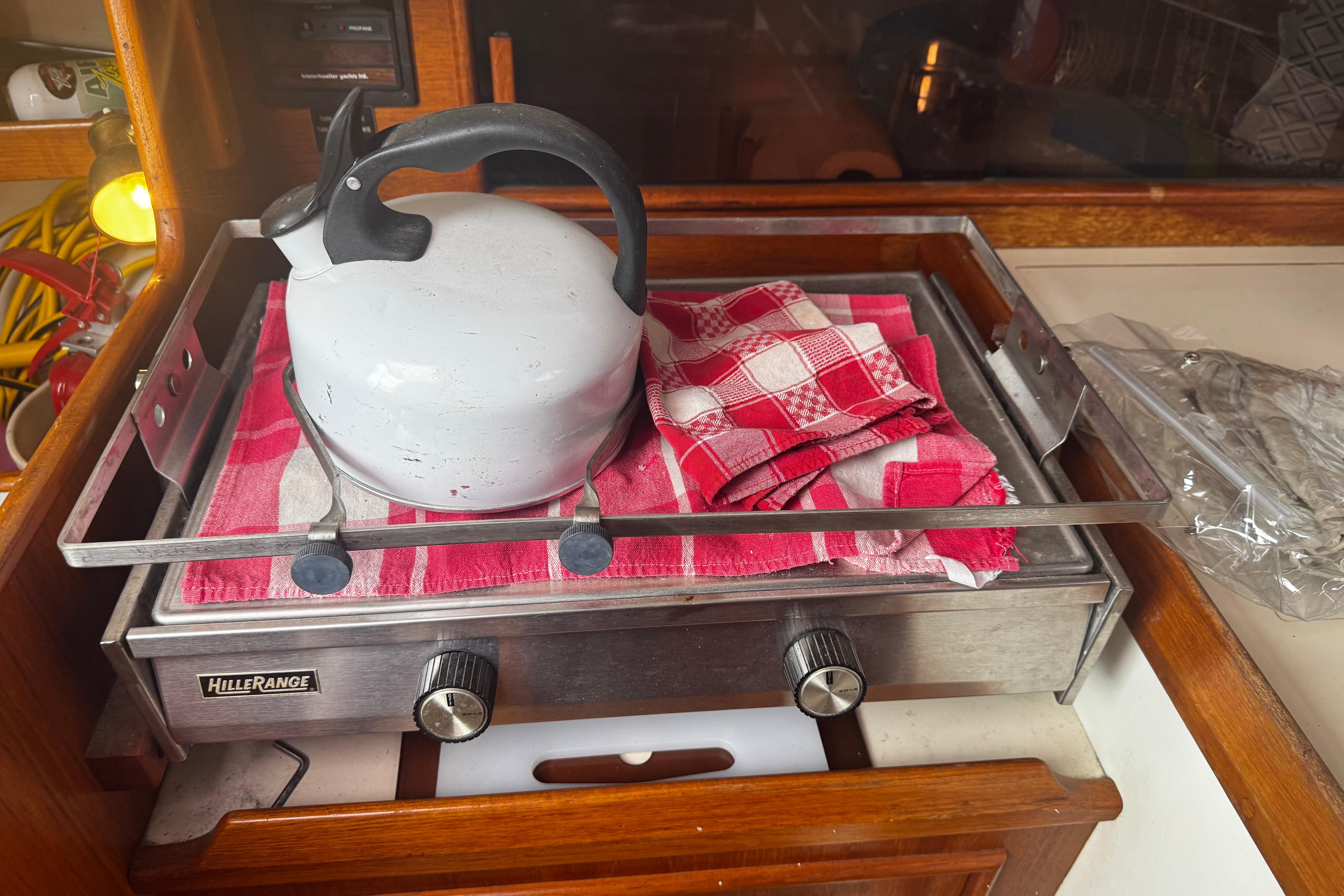 Kettle and red checkered cloth on stove inside 1984 Nonsuch 26 Classic boat.