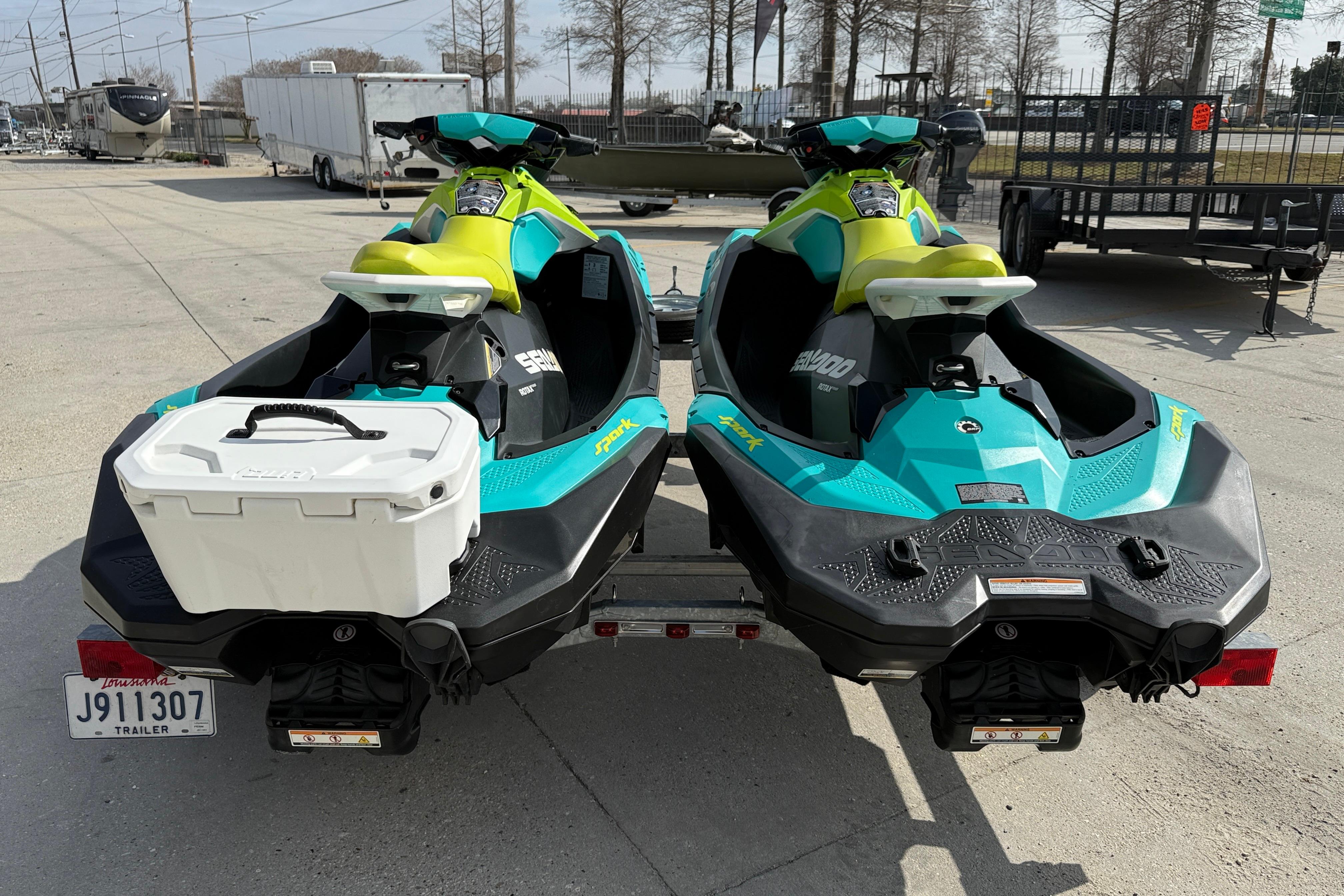 2022 Sea-Doo Spark 3up jet skis on trailer, vibrant teal and yellow design.