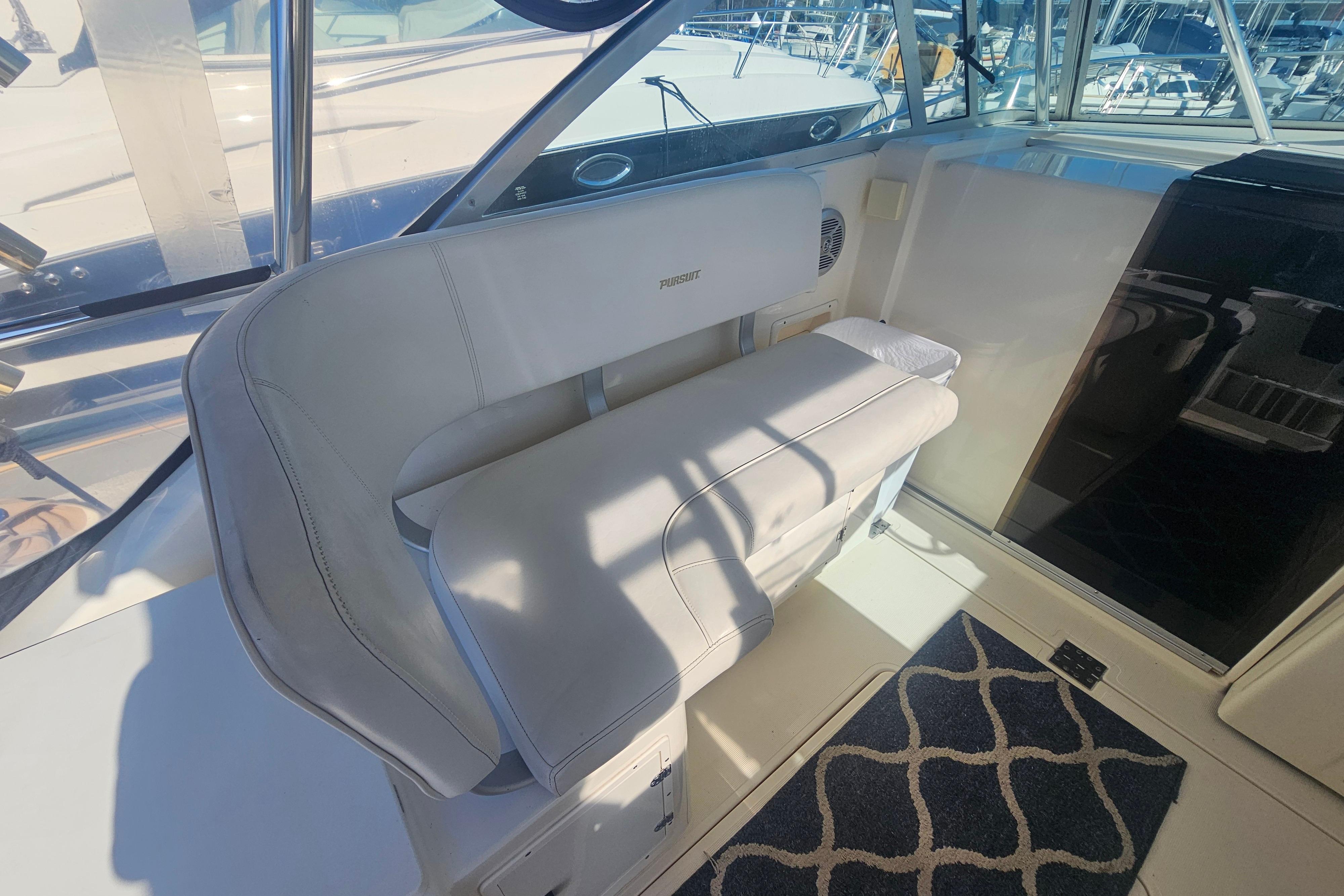 2001 Pursuit 3000 Express boat interior with cushioned seating and nautical decor.
