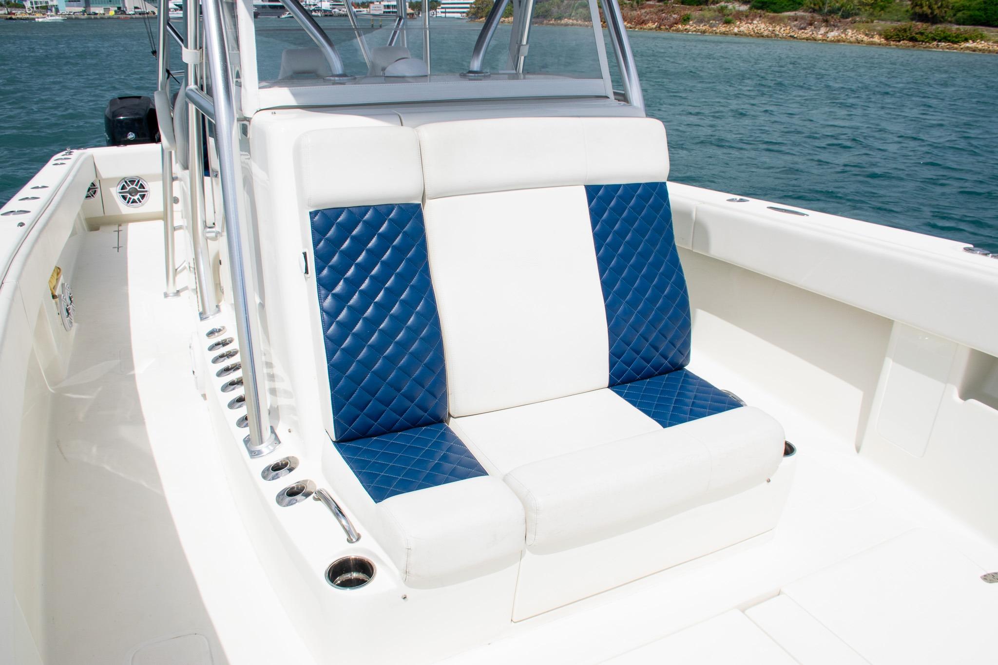 2022 SeaVee 390Z boat with blue and white seating, docked on calm water.