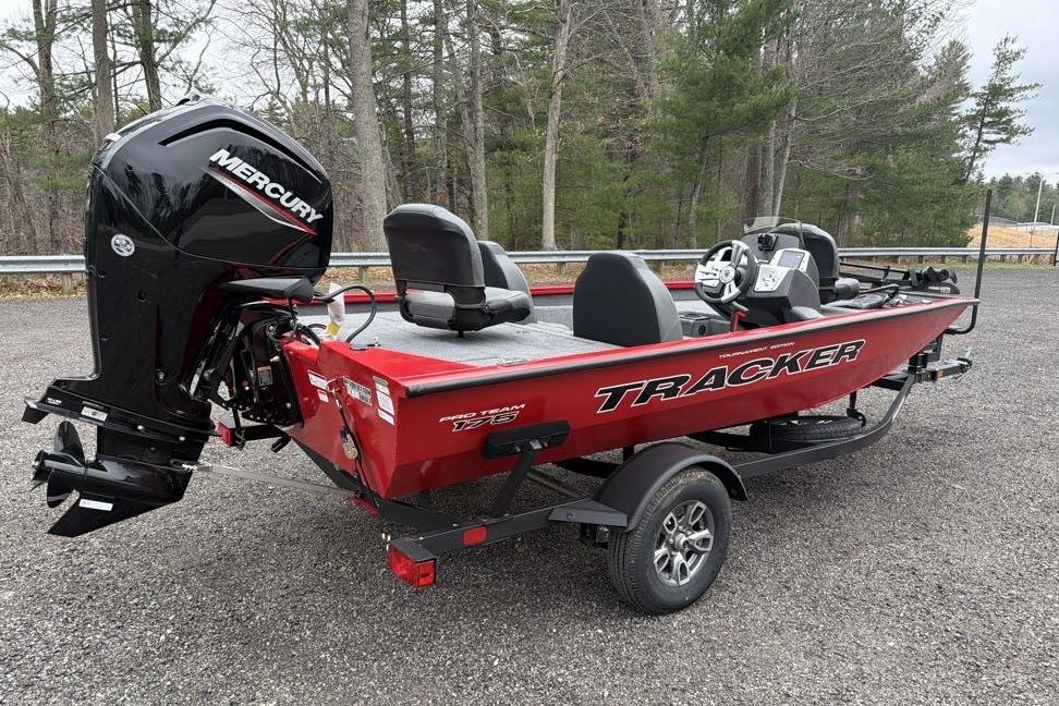 2026 Tracker Pro Team 175 boat with Mercury engine, parked outdoors on gravel.