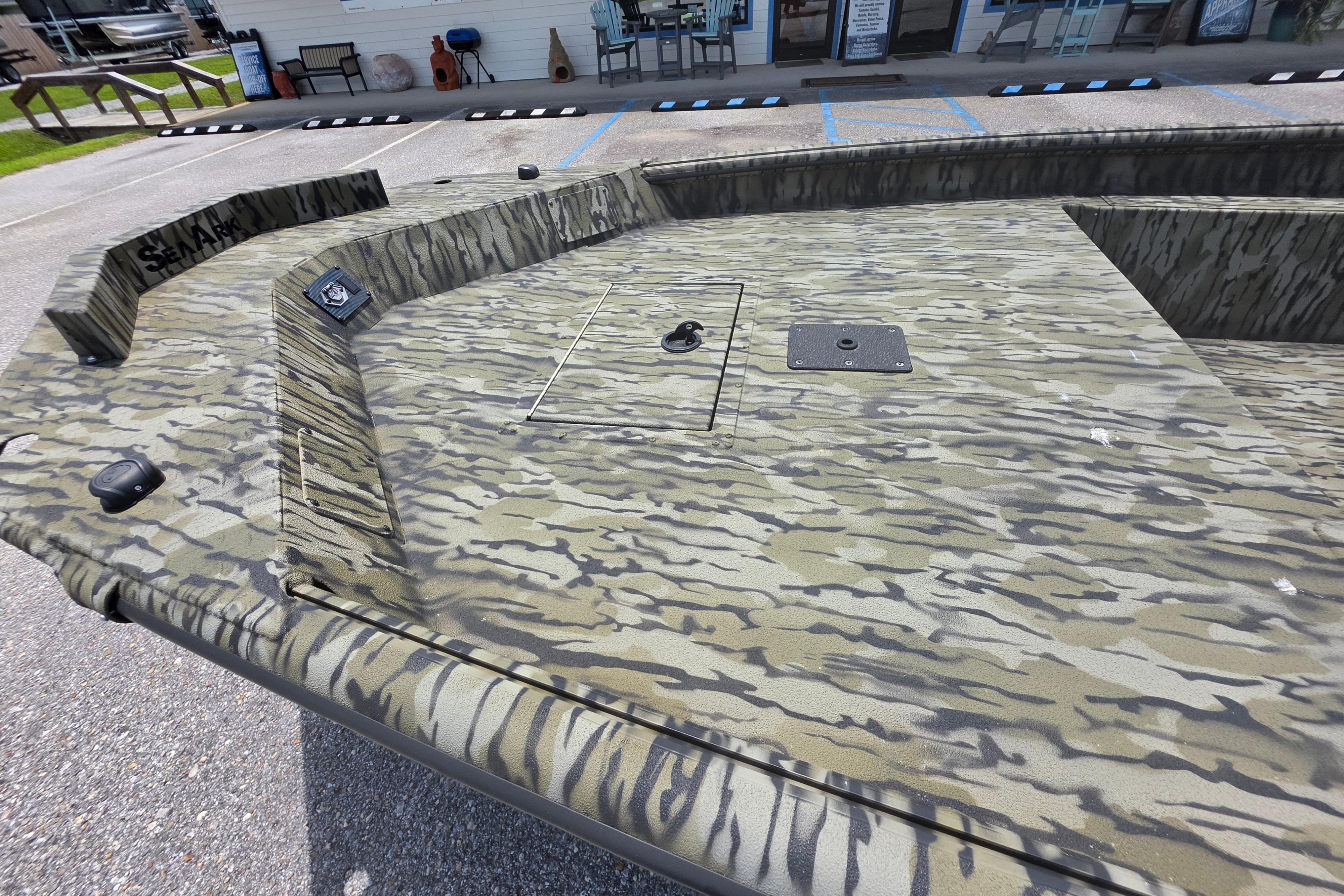 2025 SeaArk 1752 Slayer boat with camouflage pattern, parked outdoors.