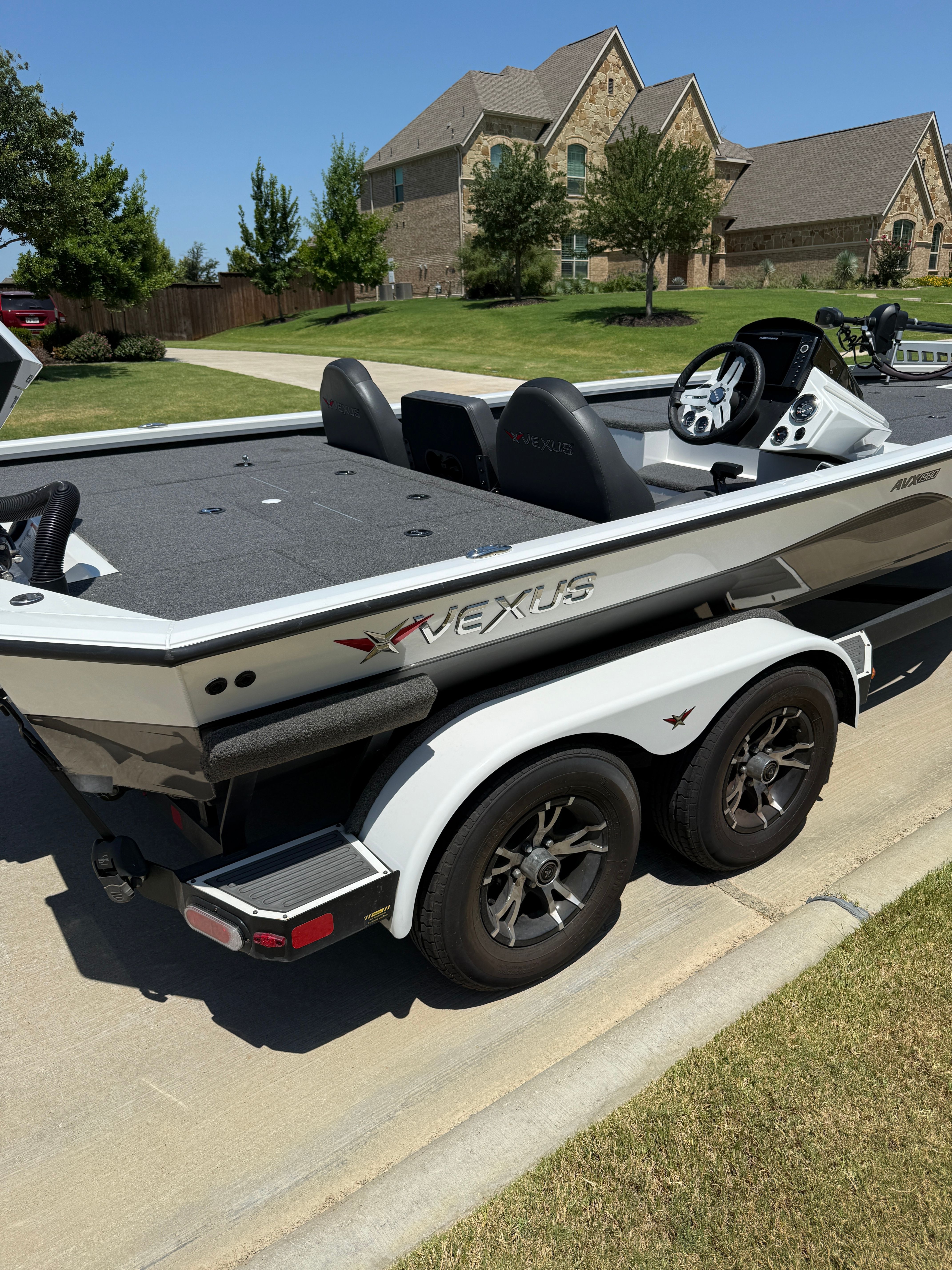 A 2019 Vexus AVX1980 boat on a trailer in a residential area.
