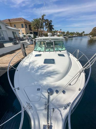 2006 Tiara Yachts 3200 Open docked by waterfront homes under a clear sky.