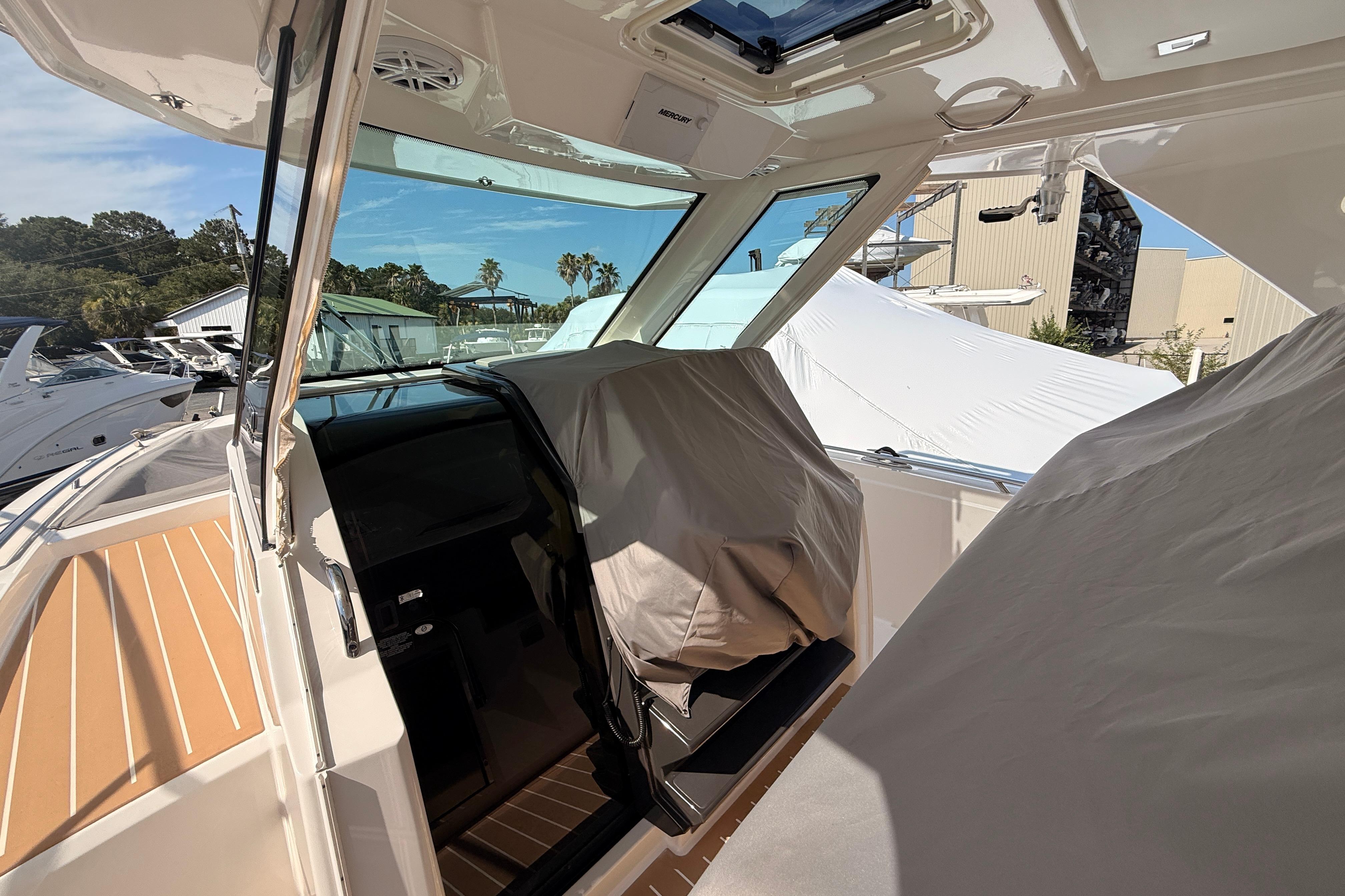 2024 Tiara Yachts 34 LS interior with covered seating and modern dashboard.