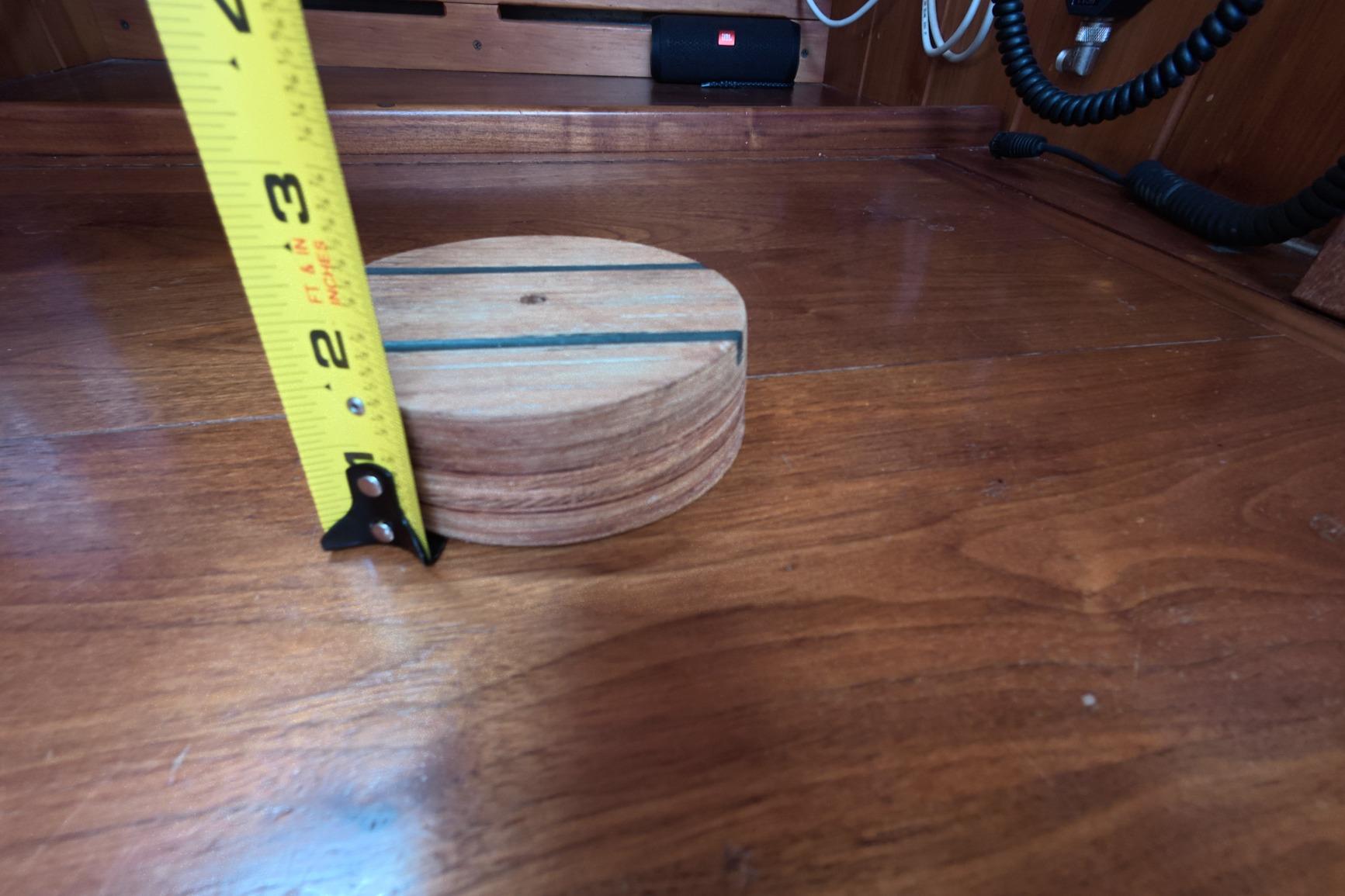 Wooden surface with a round wooden object and a measuring tape, inside a 1987 Custom Wittholtz/Luzier Sloop/Cutter.