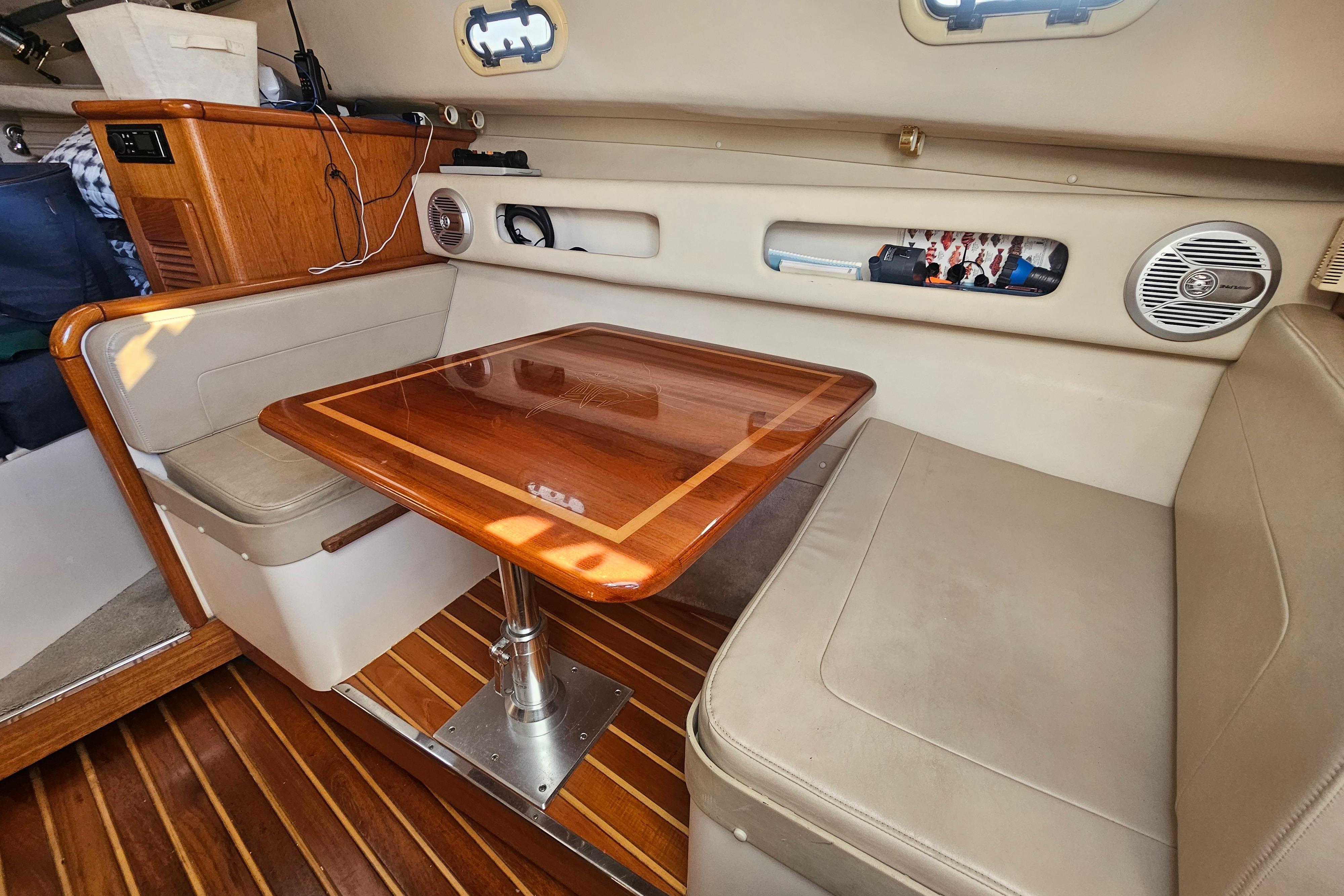 2001 Pursuit 3000 Express cabin with wooden table and cushioned seating.