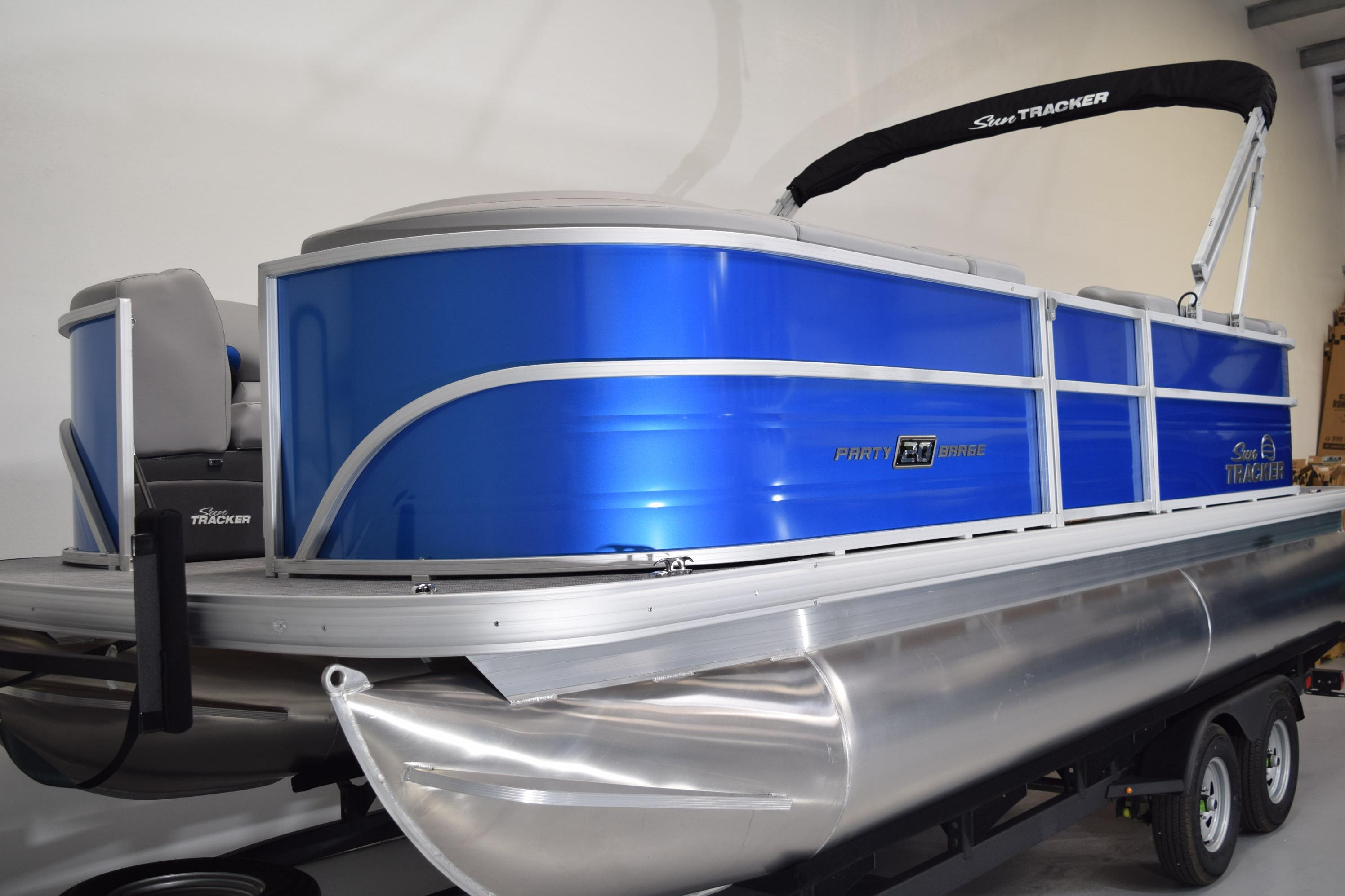 2026 Sun Tracker Party Barge 20 DLX pontoon boat with blue exterior on trailer.