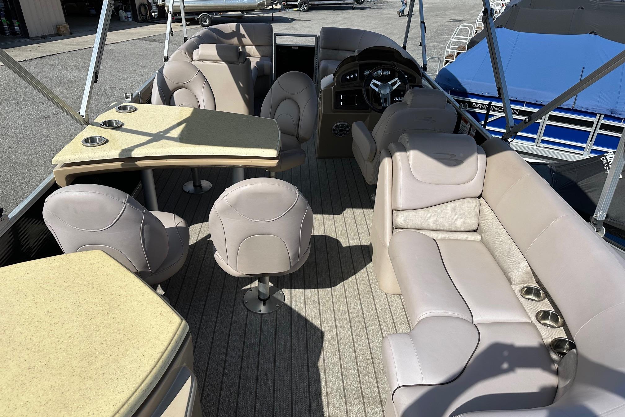 2017 Bennington 22 GPD pontoon boat interior with beige seating and tables.