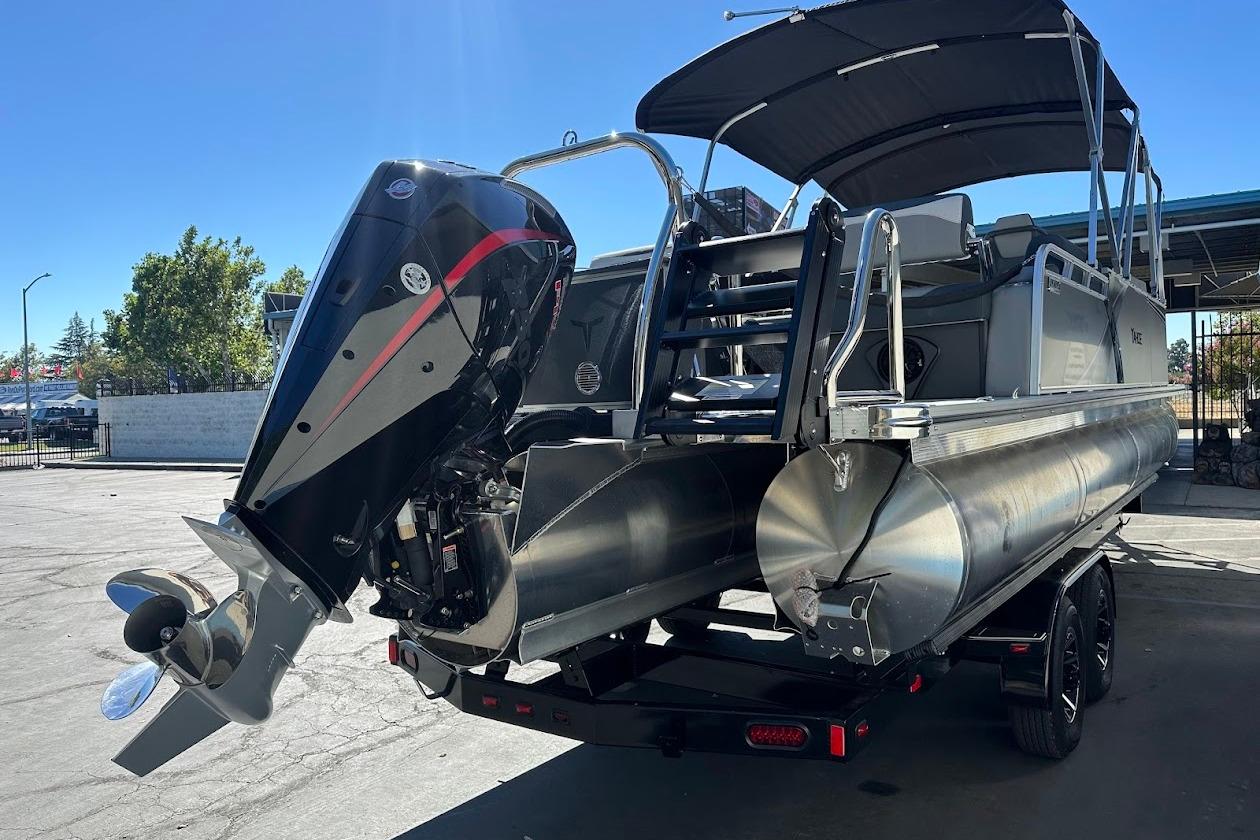 2026 Tahoe Pontoon LTZ Quad Lounger Shift 23 with powerful outboard motor, docked outdoors.