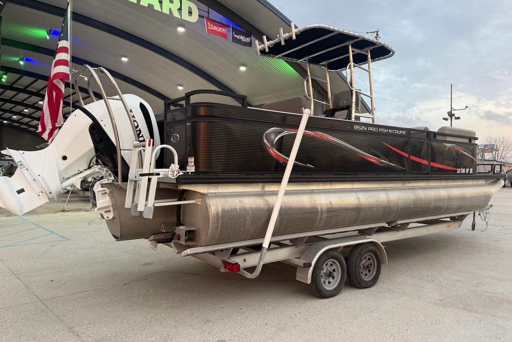 2022 Apex Marine 8524 Pro Fish N Cruise pontoon boat on trailer, parked outside dealership.