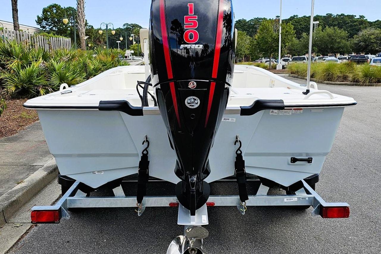 2026 Mako Pro Skiff 19 CC with 150 HP engine on trailer, parked outdoors.
