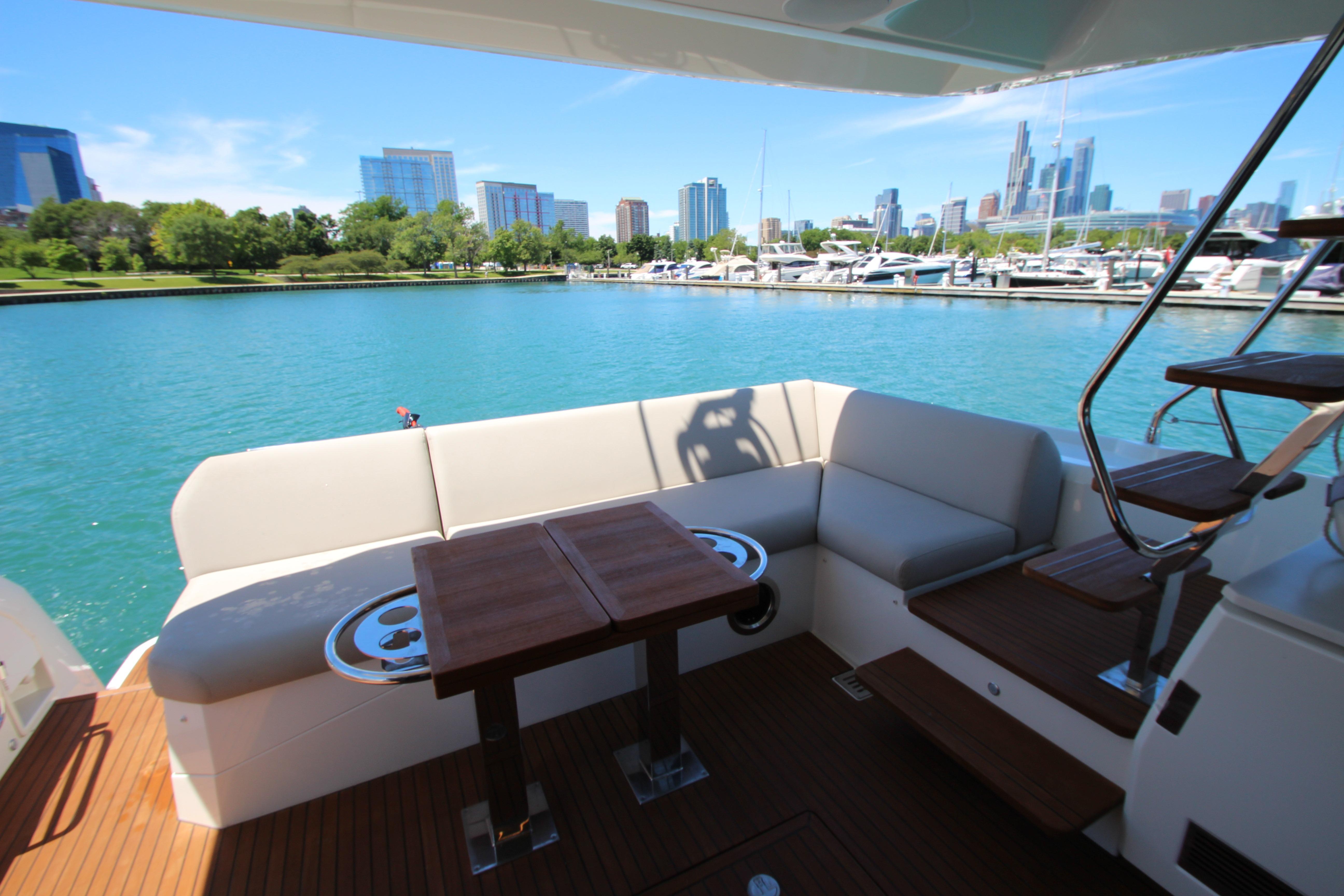Luxurious 2022 Prestige 520 yacht deck with city skyline and marina view.