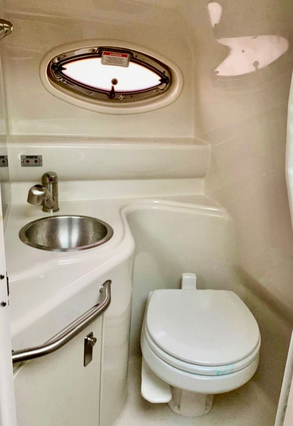Compact bathroom in 2012 Sea Ray 240 Sundancer boat with sink and toilet.