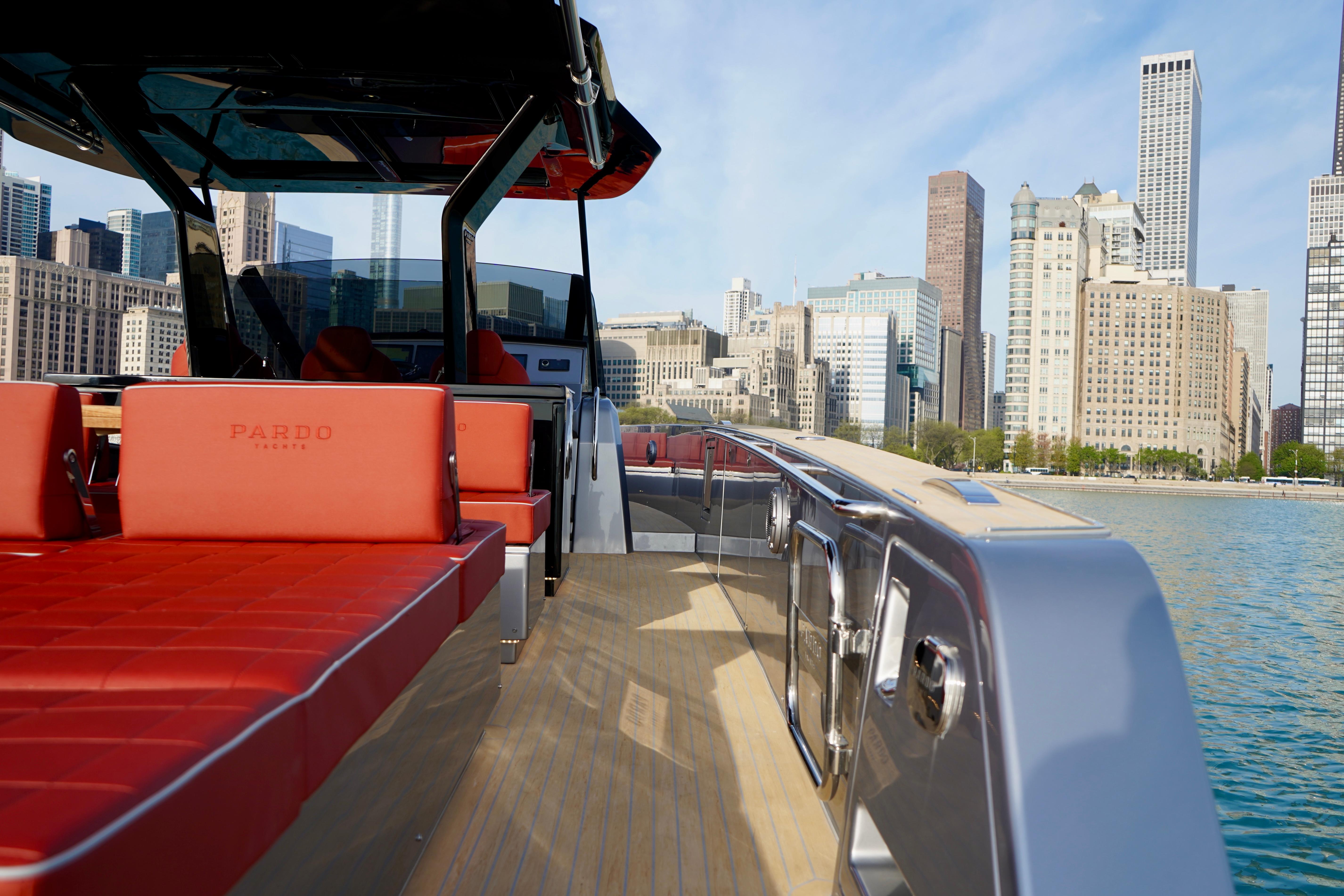 2025 Pardo Yachts 43 with red seating, city skyline in background, docked by the water.