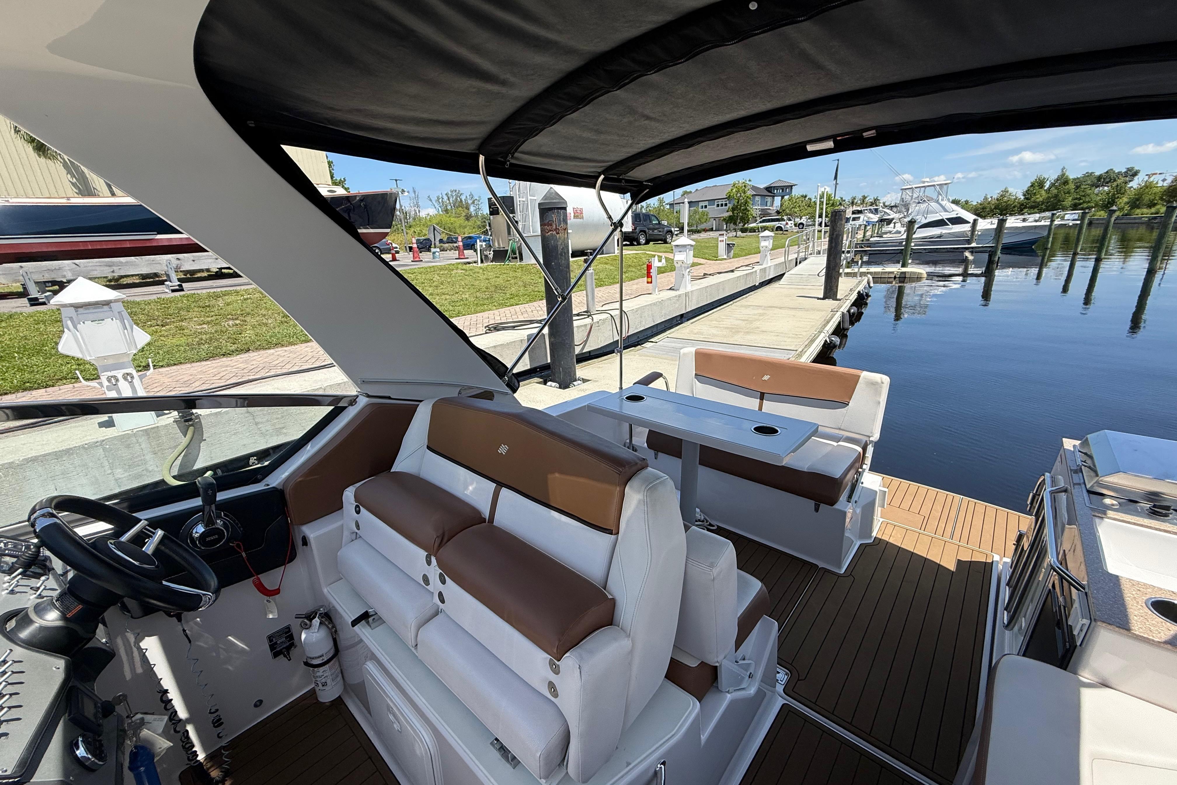 2017 Four Winns V275 boat interior with seating and helm, docked at a marina.