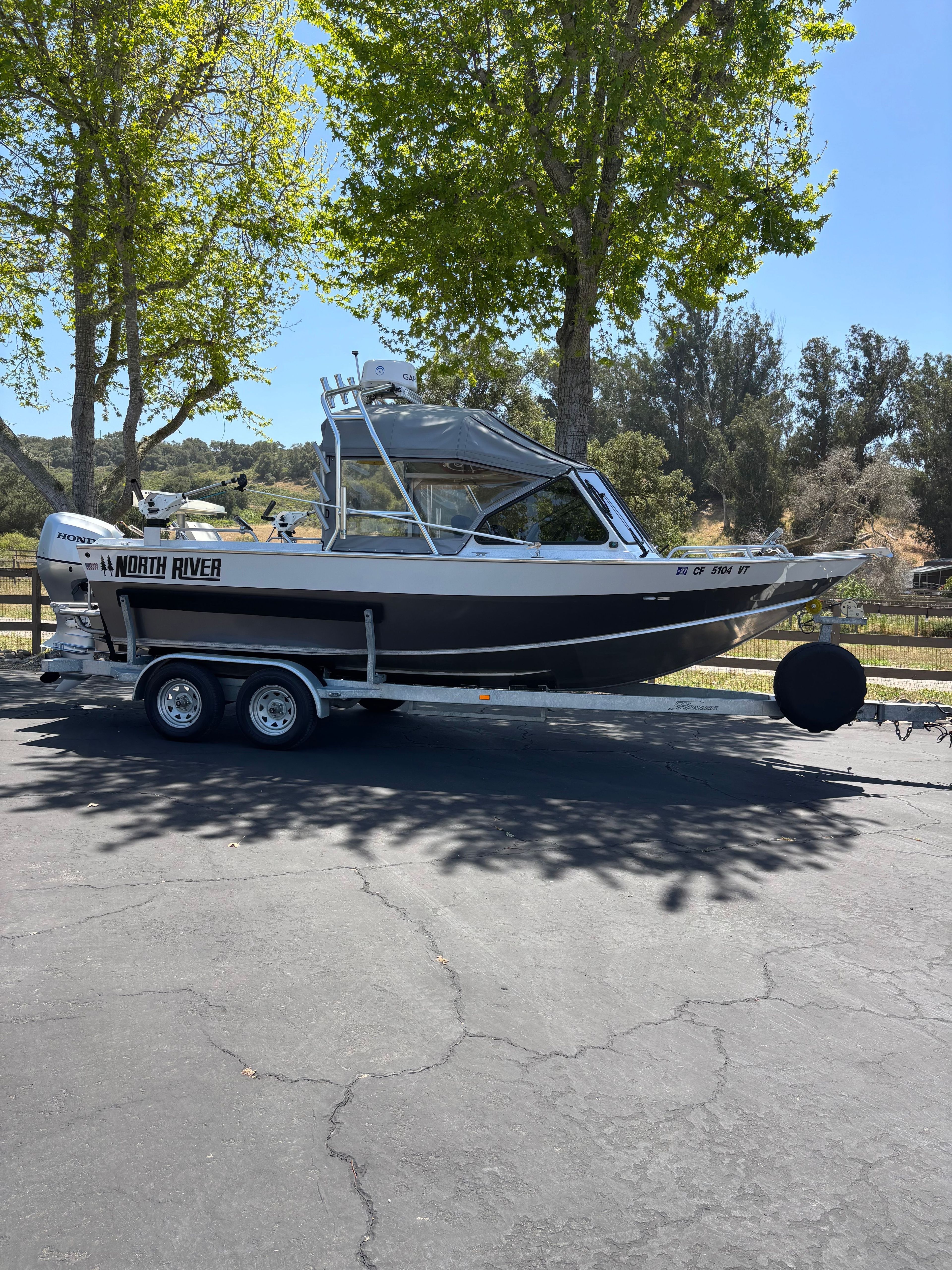2020 Sea Hawk North River boat on trailer under trees.