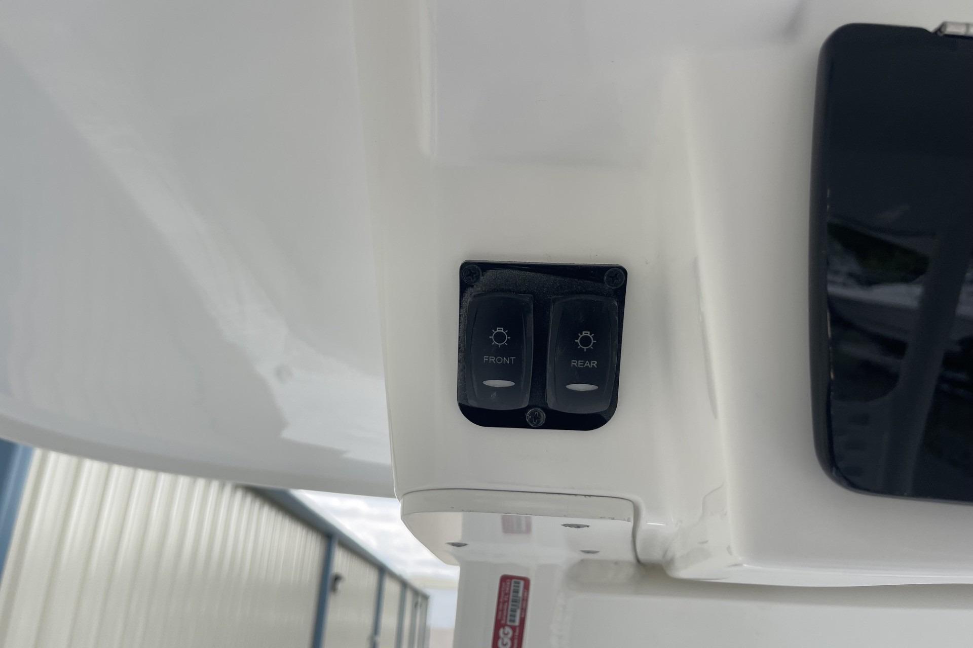 Switch panel on 2026 Hurricane Center Console 24 OB boat, featuring front and rear light controls.