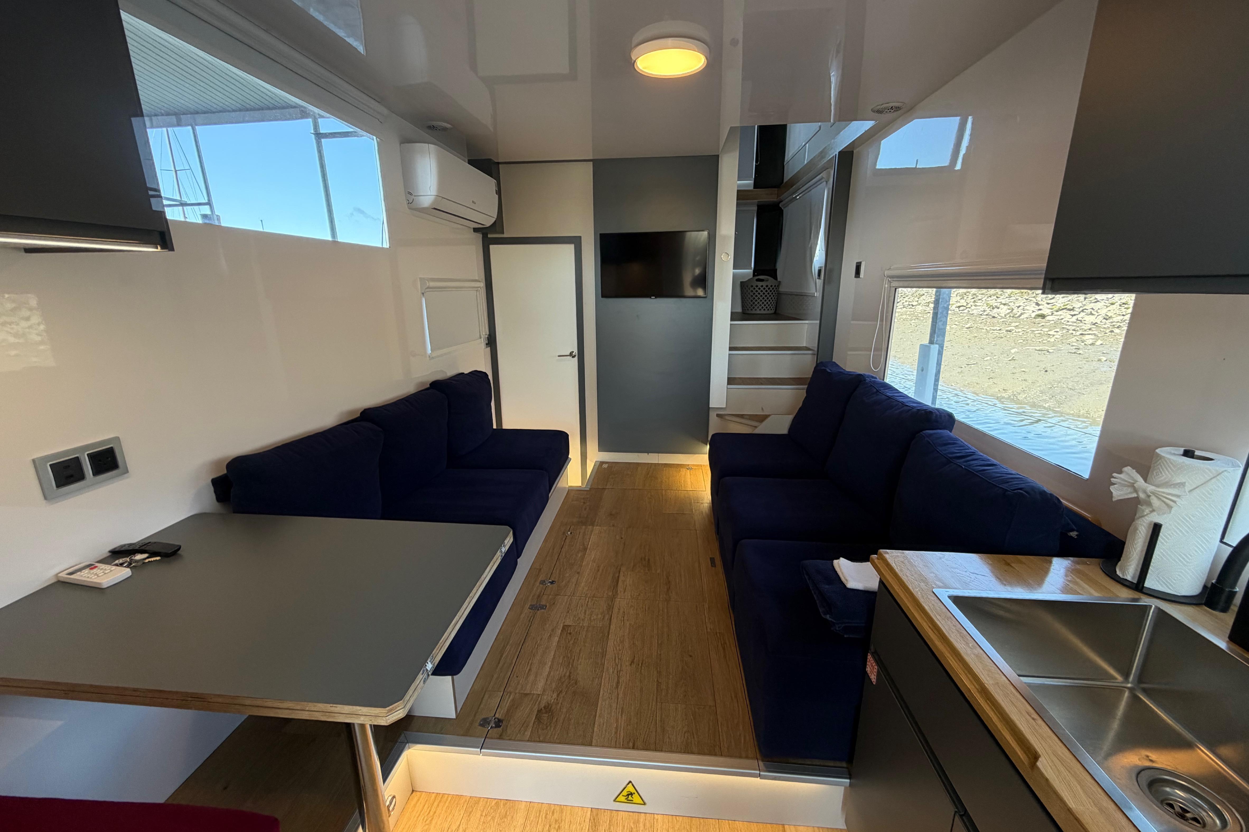 Modern interior of 2022 Navisyo NV.08 with cozy seating, kitchenette, and natural light.