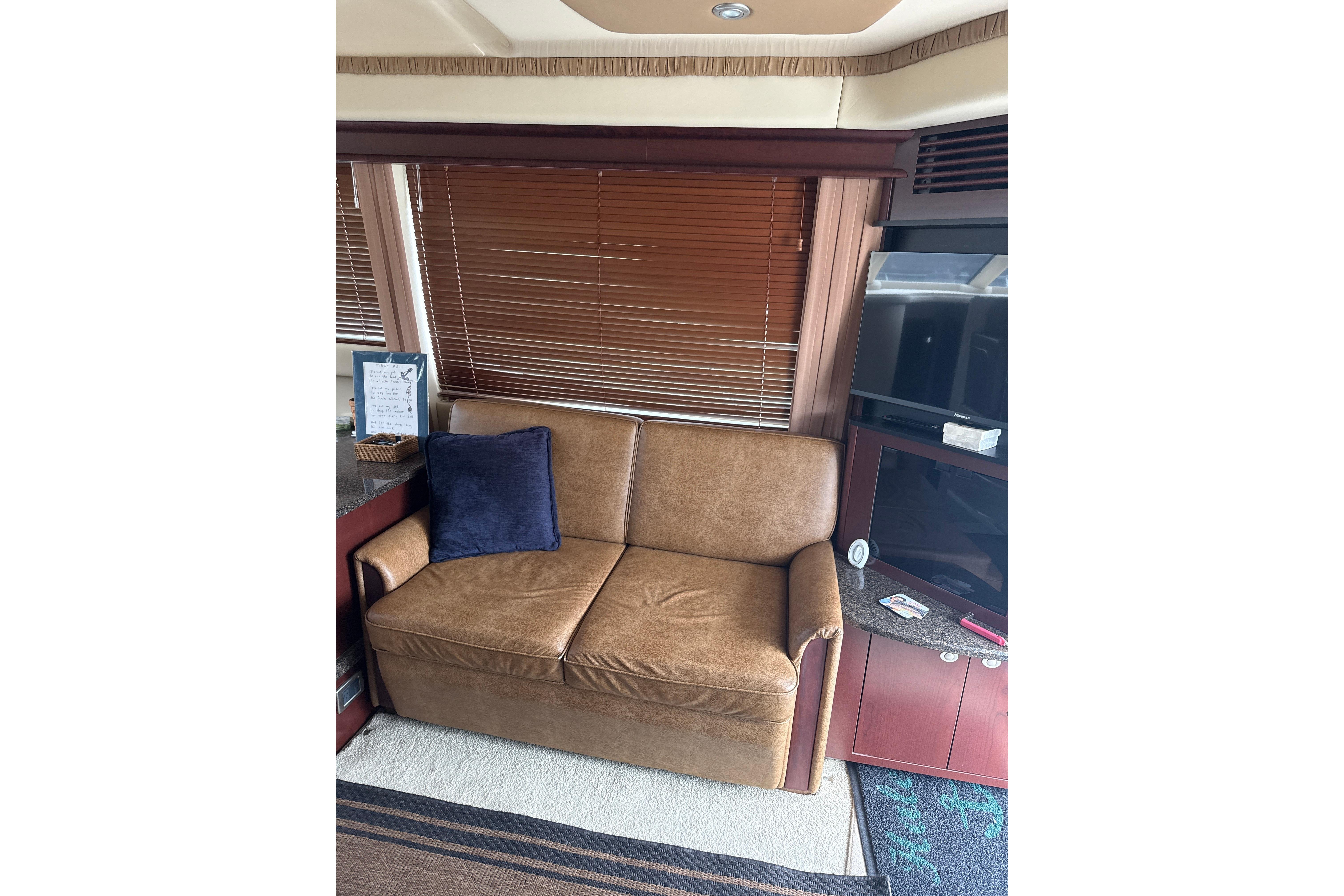 Interior of 2007 Sea Ray 44 Sedan Bridge with leather sofa and TV.