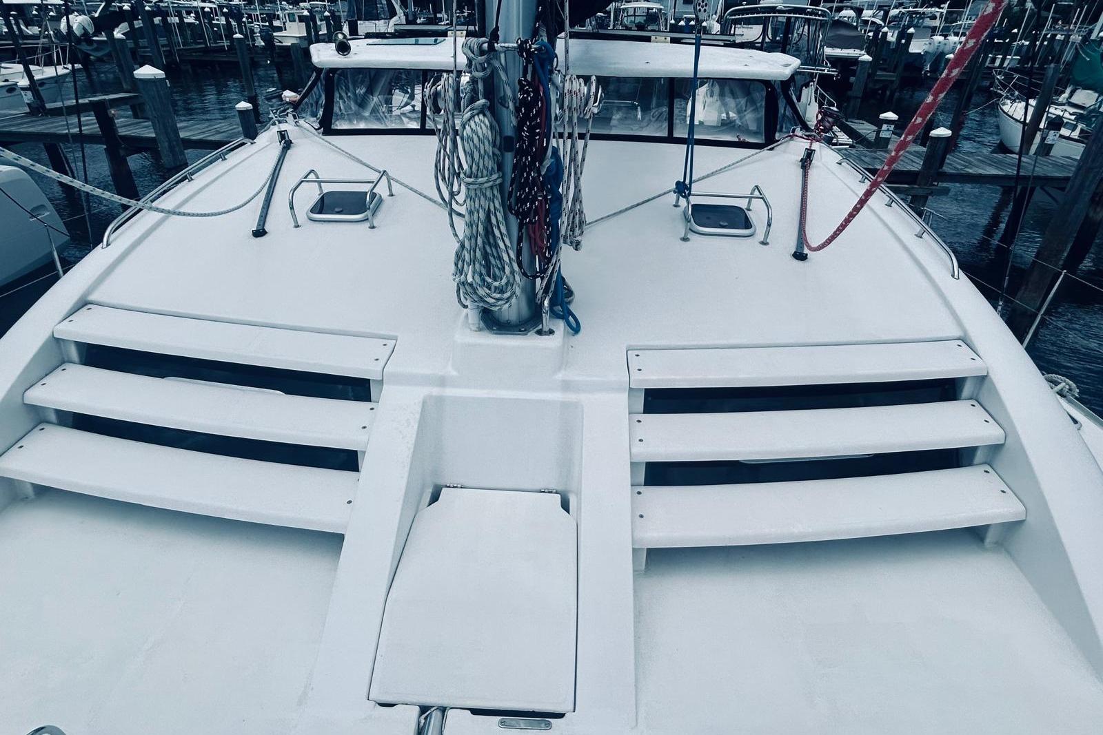 2001 Robertson & Caine Leopard catamaran deck with steps and rigging in a marina.