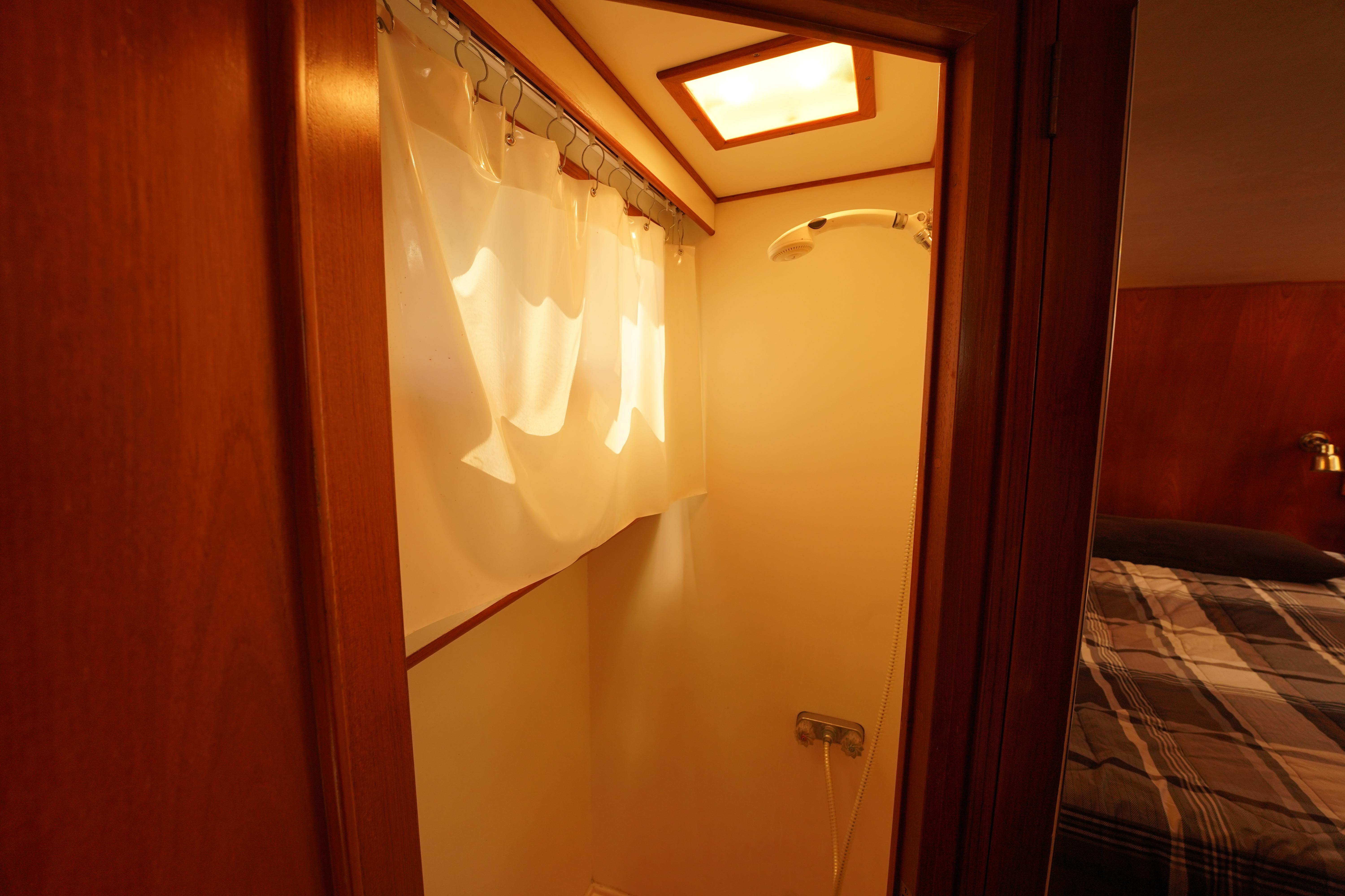 Shower area in 1986 Ocean Alexander 40 Double Cabin yacht with curtain and wooden accents.