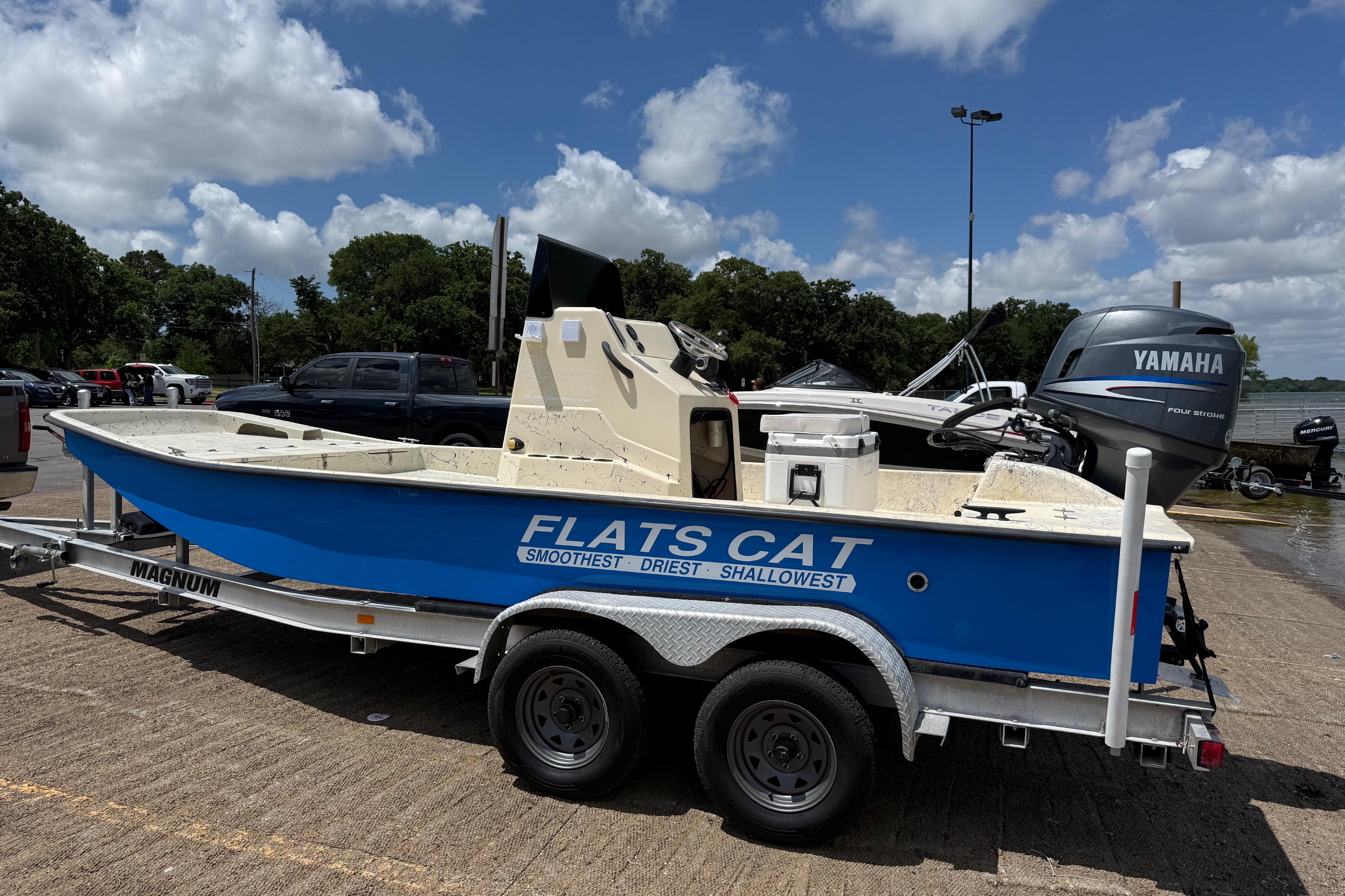 2007 Flats Cat 19 boat on trailer with Yamaha outboard motor, parked under blue sky.