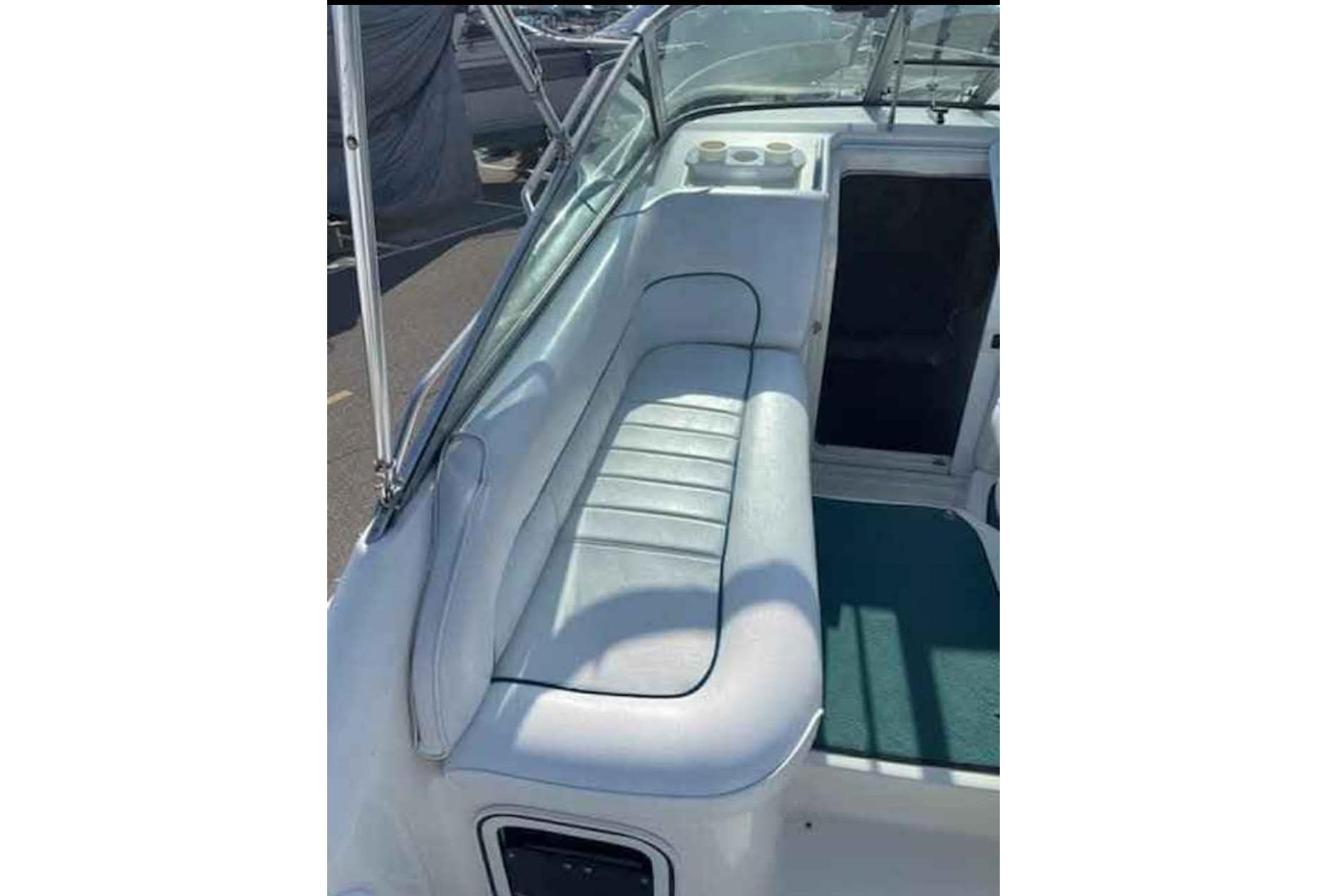 1996 Sea Ray 270 Sundancer boat interior with cushioned seating and cup holders.
