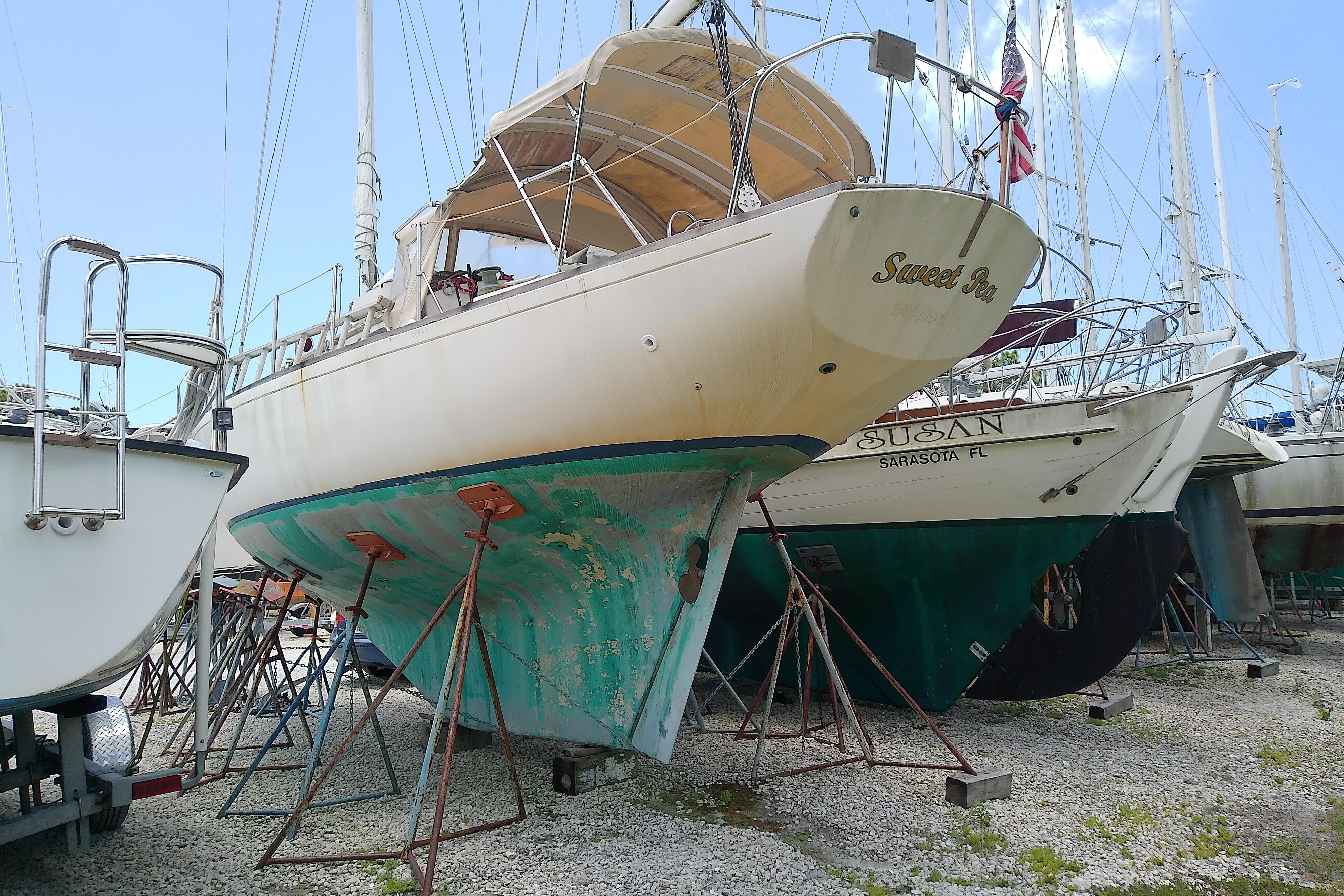 1981 Sea Sprite 34 sailboat on stands in a boatyard, hull showing wear.