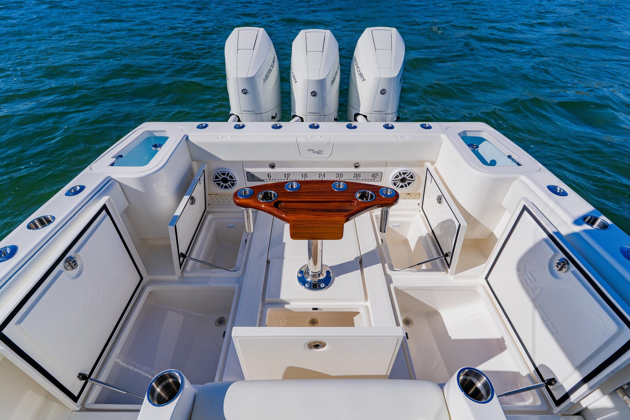 2025 SeaVee 370Z boat deck with triple Mercury engines, fishing rod holders, and storage compartments.