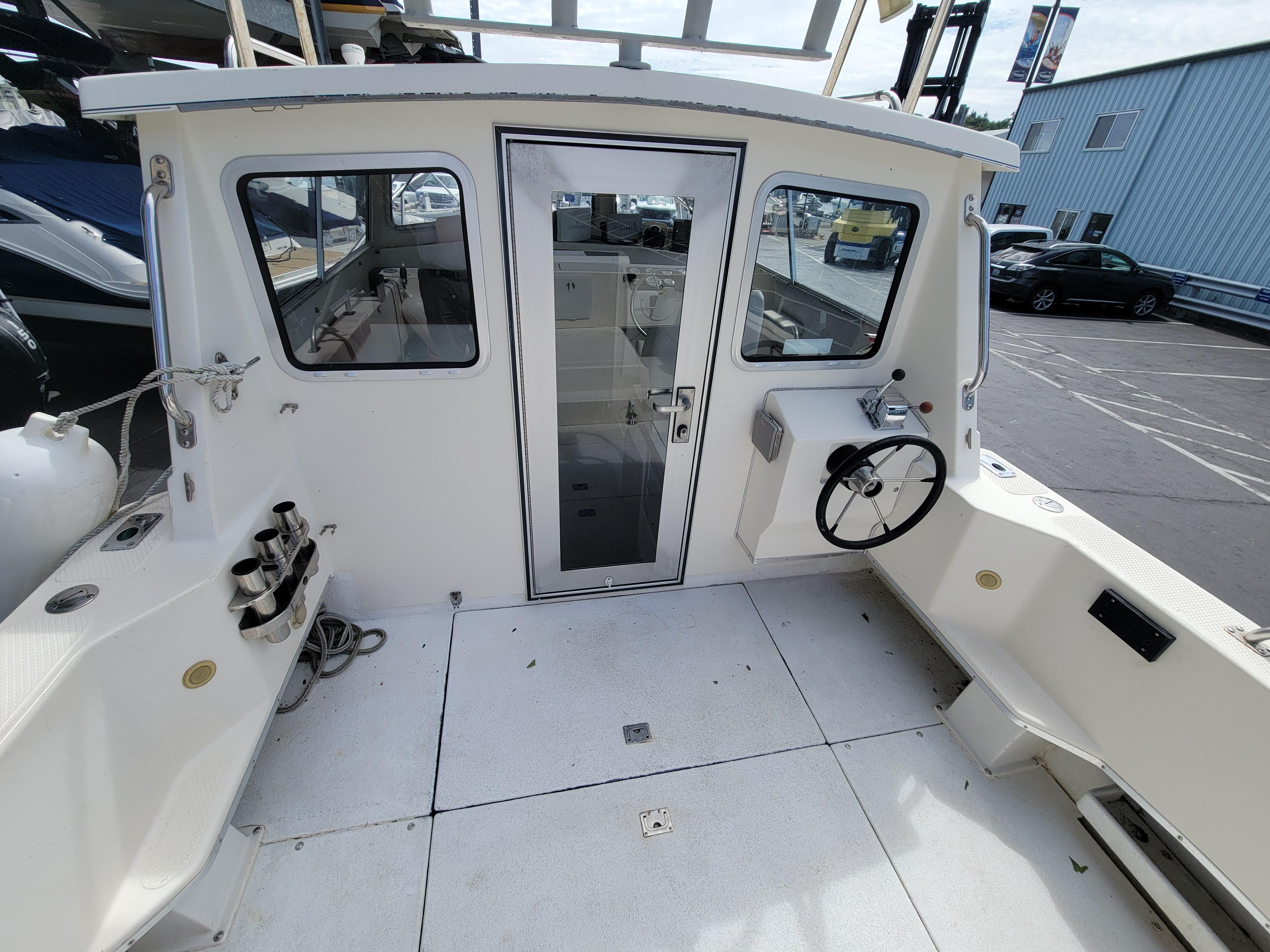 1999 SeaSport 2400 XL Limited boat cockpit with steering wheel and cabin door.