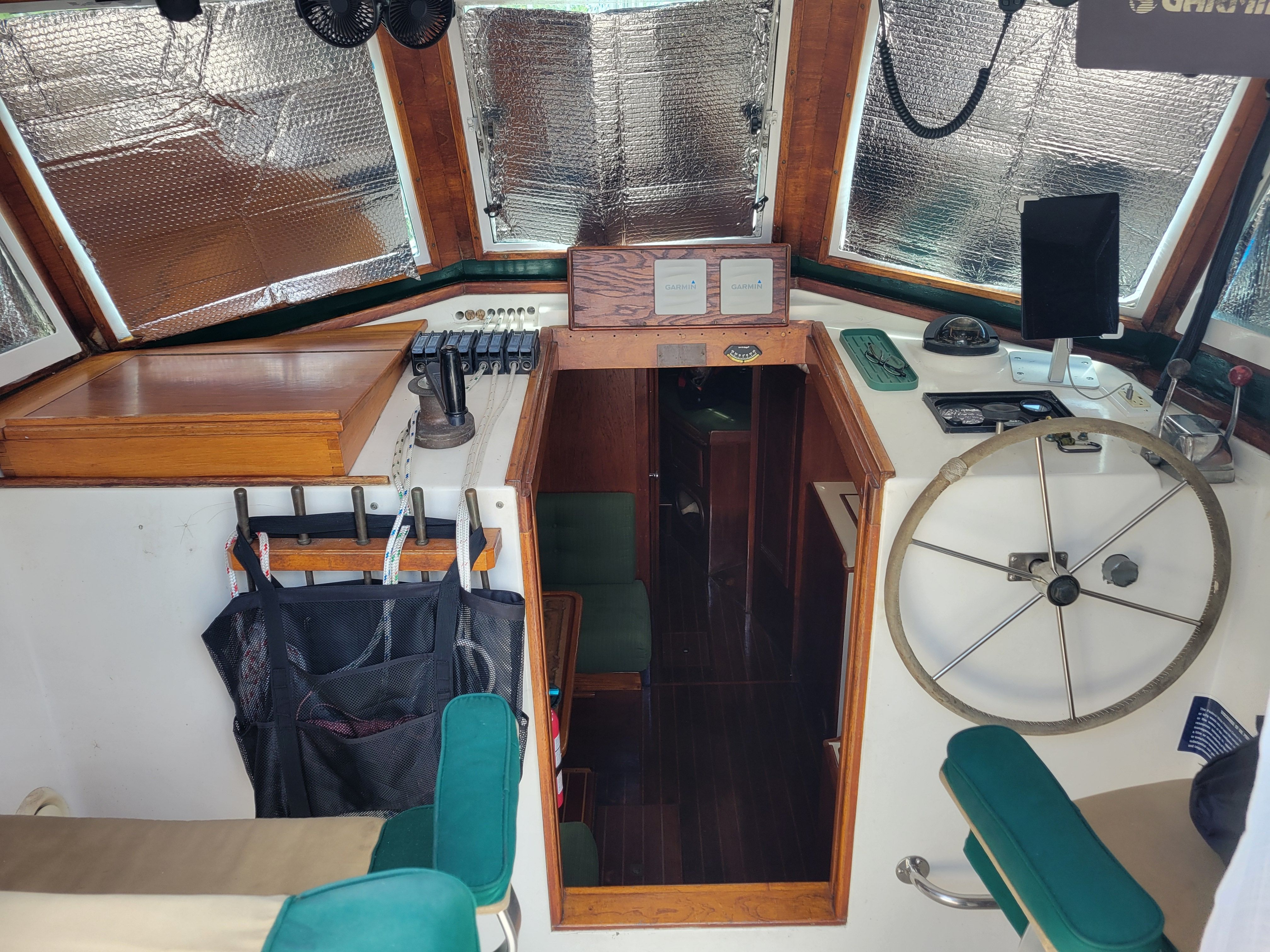 Interior of a 1989 Cape Dory MS300 with a steering wheel and wooden features.
